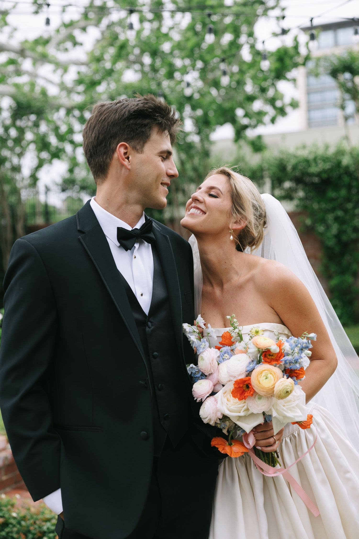 Romantic wedding portraits captured in a garden setting with natural lighting.