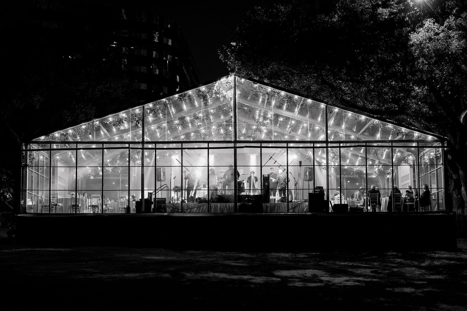 Panoramic view of a modern glass wedding venue glowing in the evening.