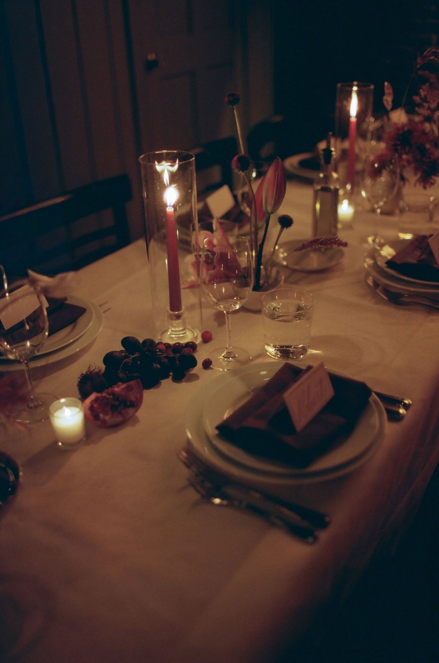 Romantic candlelit dinner table settings with elegant place settings and soft glowing ambiance.