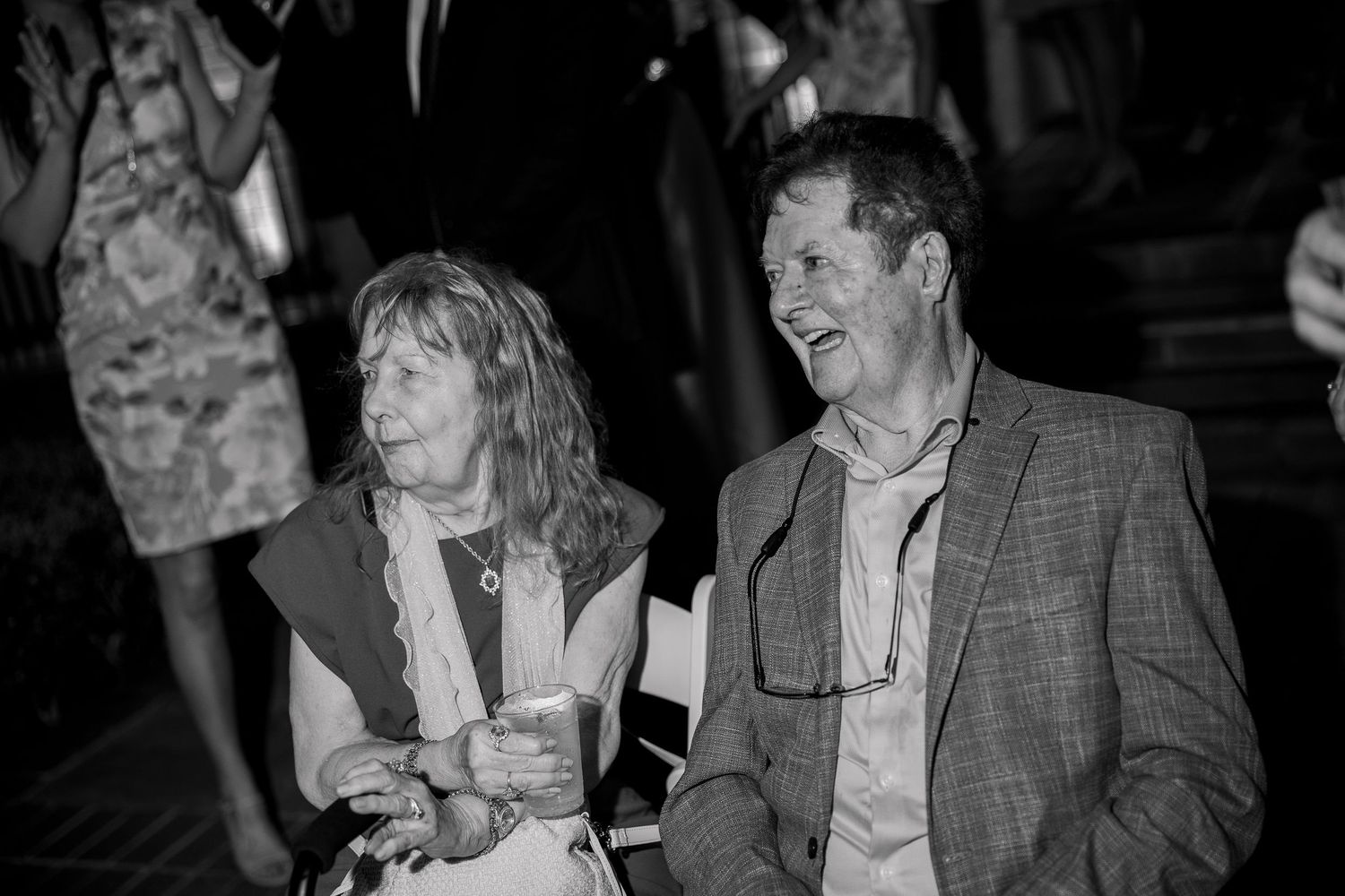 Black and white photo of guests chatting at a formal evening event.