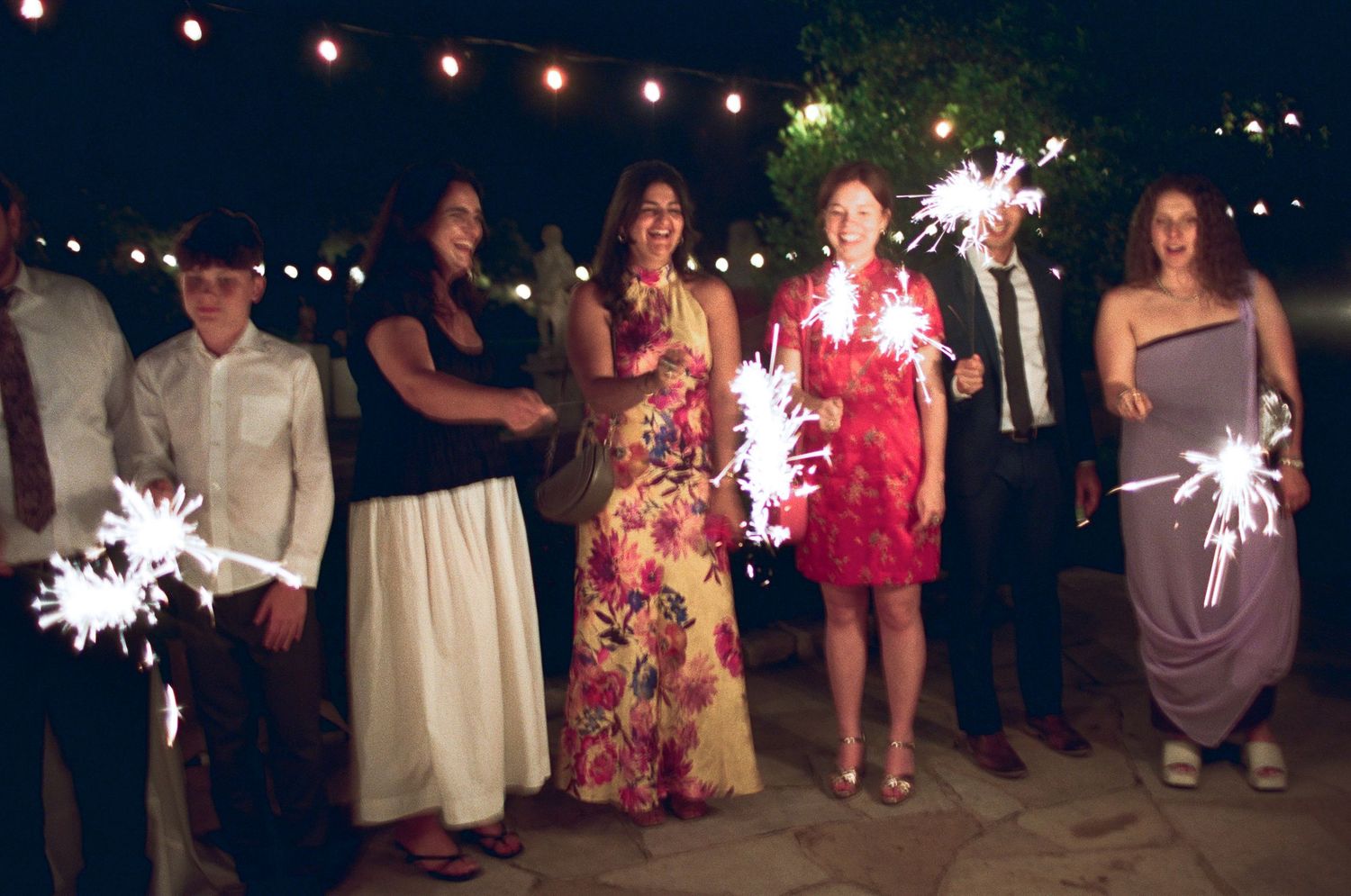 Wedding celebration at night with string lights creating a magical atmosphere.