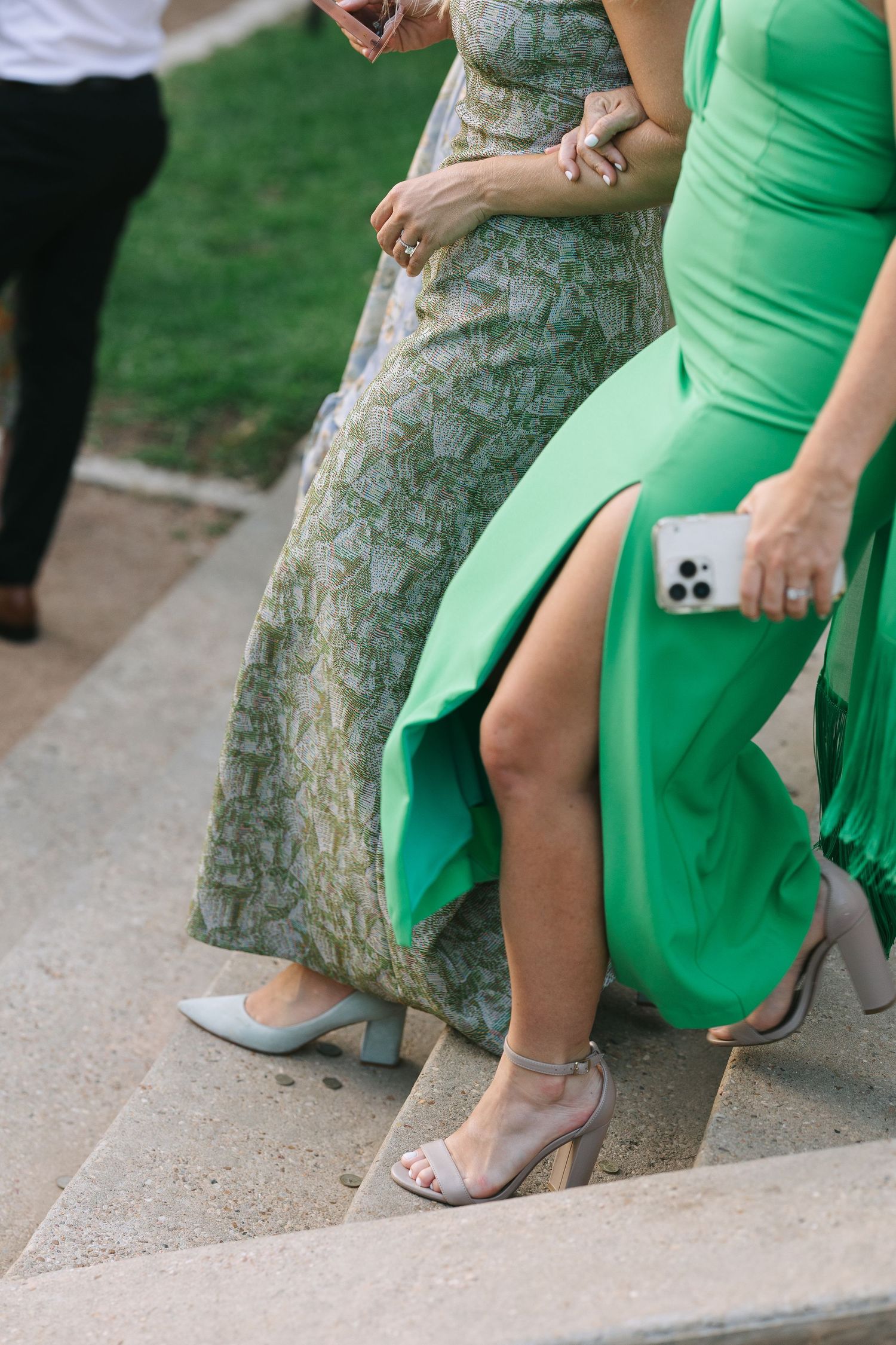 Women in green and floral dresses showing their formal footwear.
