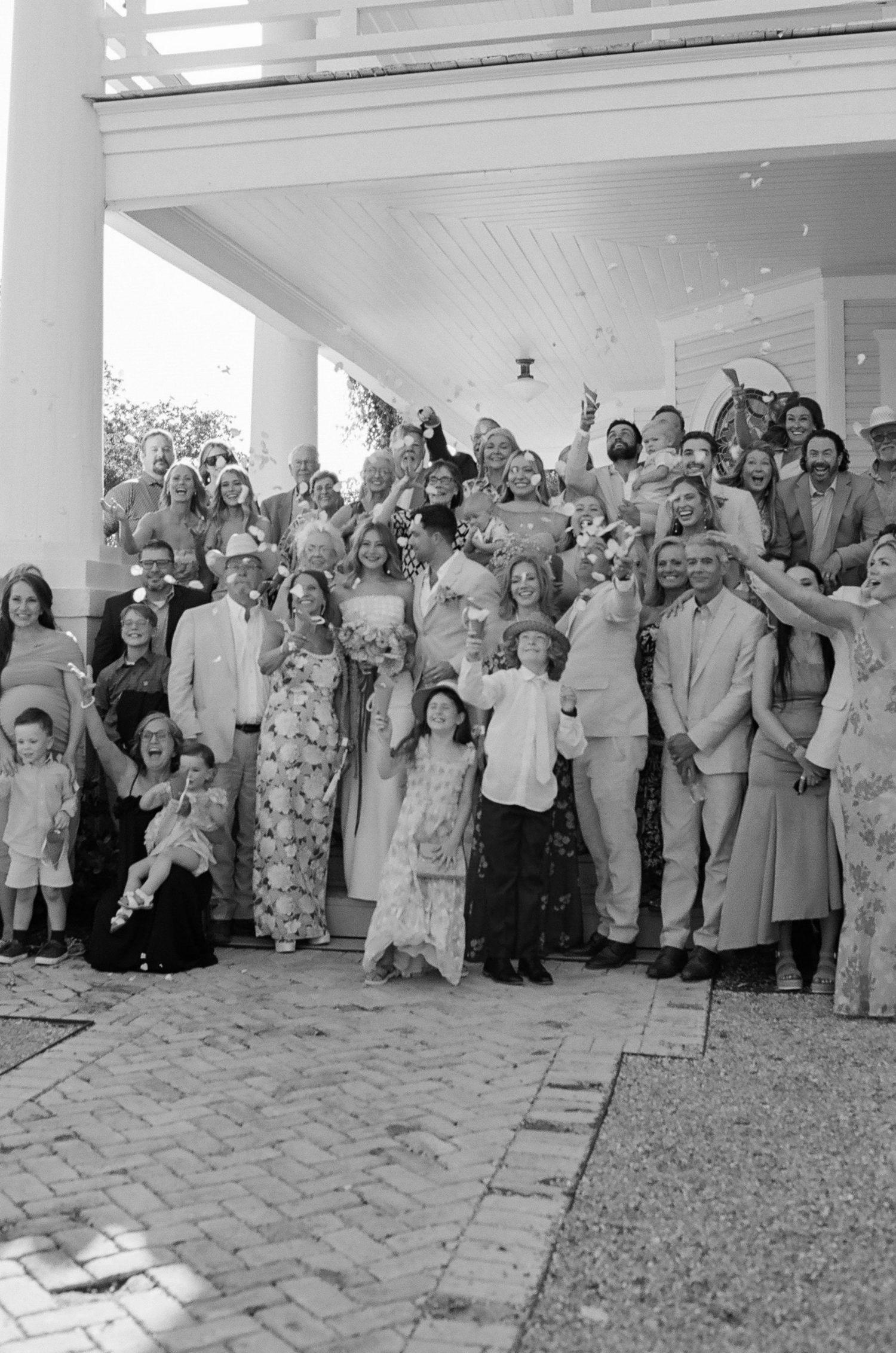 Large group of wedding guests gathered outside a venue for a formal celebration.