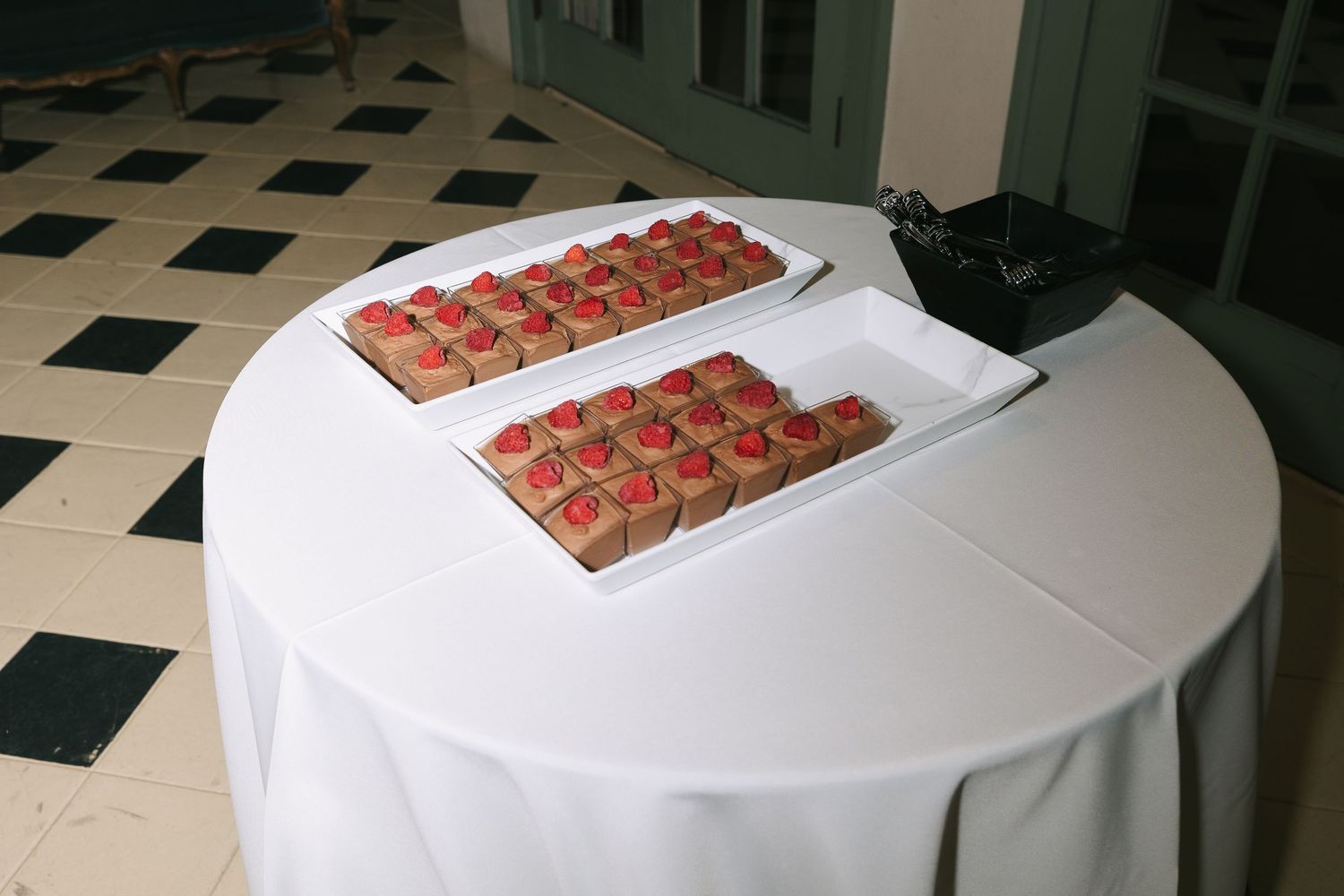 Desserts arranged on white tablecloths at a formal event.