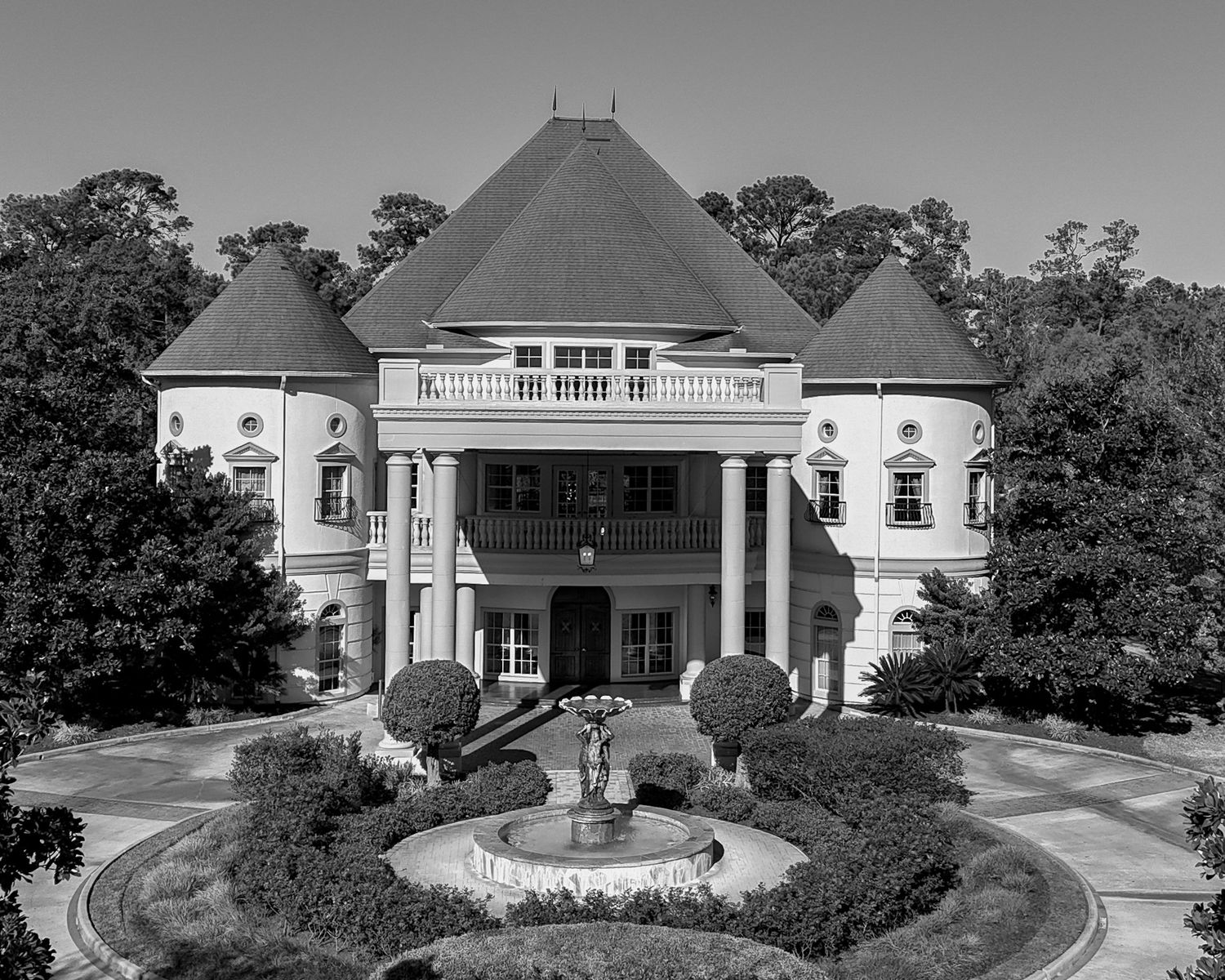 Panoramic black and white view of a luxurious estate with multiple buildings and circular driveways.