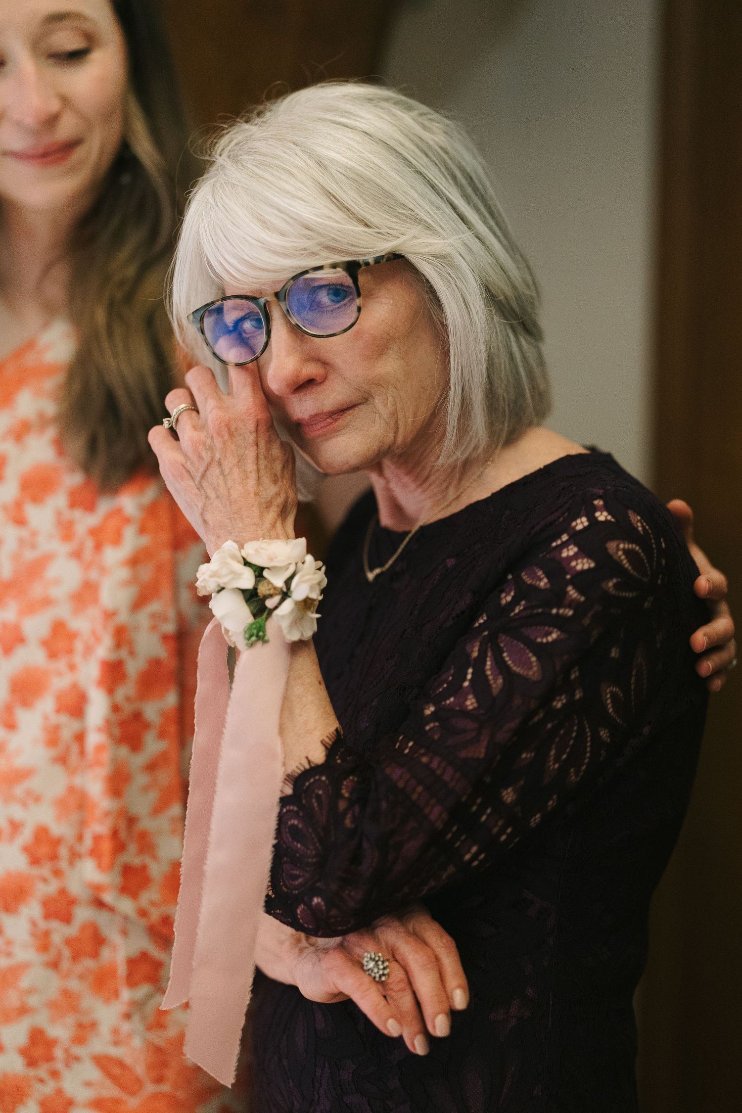 An emotional moment captured at a celebration as someone in black lace wipes away tears.