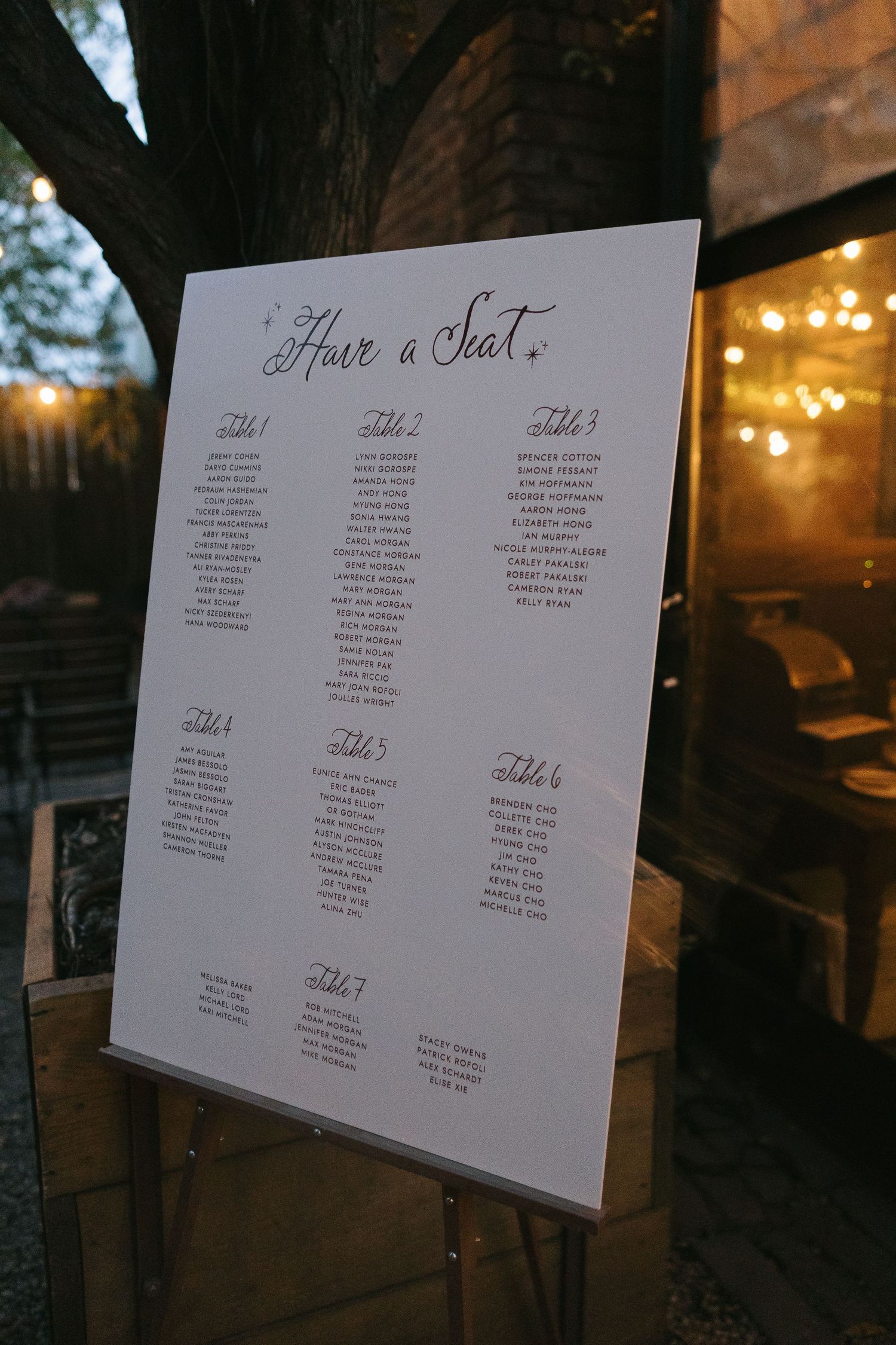 Wedding seating chart displayed on white boards showing table assignments for guests.