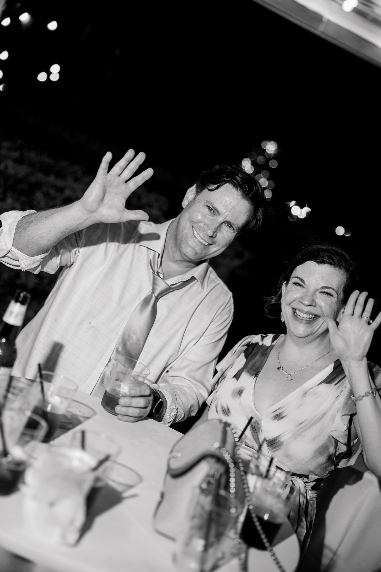 Party guests laughing and celebrating at a festive event in black and white.
