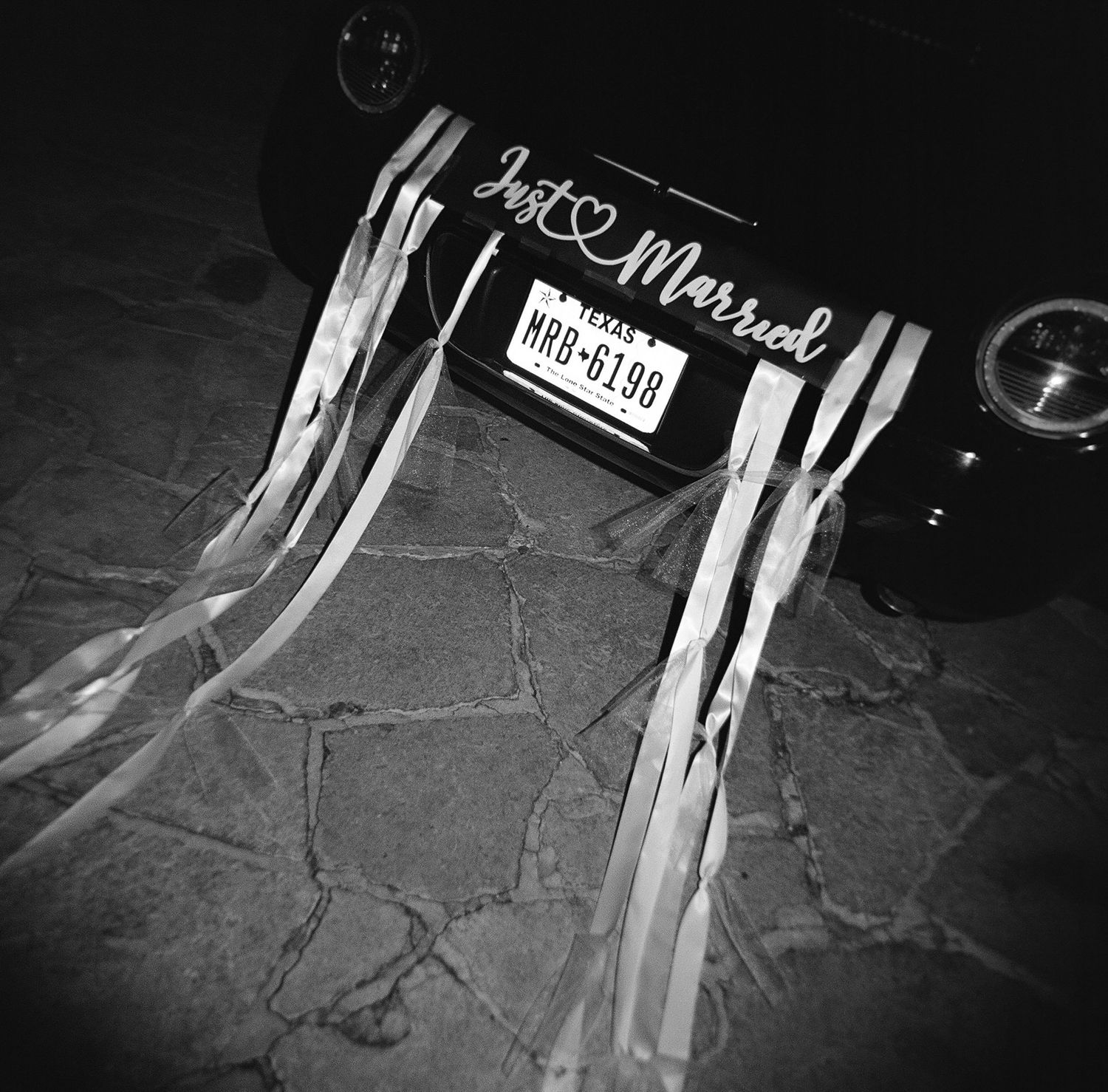 Black and white detail of wedding decorations and signage in dark lighting.