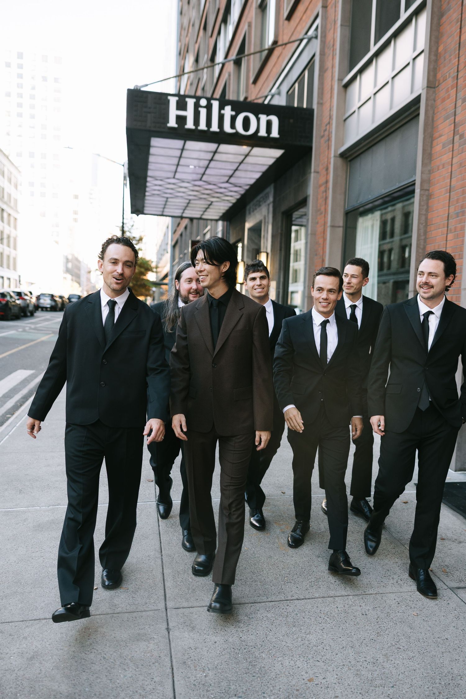 Group of formally dressed people walking outside the Hilton hotel.