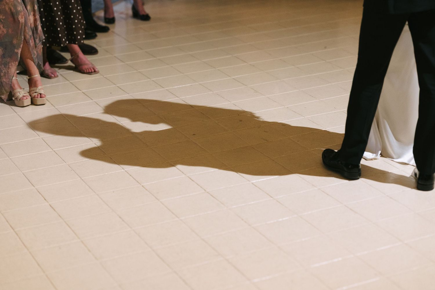 Shadows cast on a light wooden floor during an event.