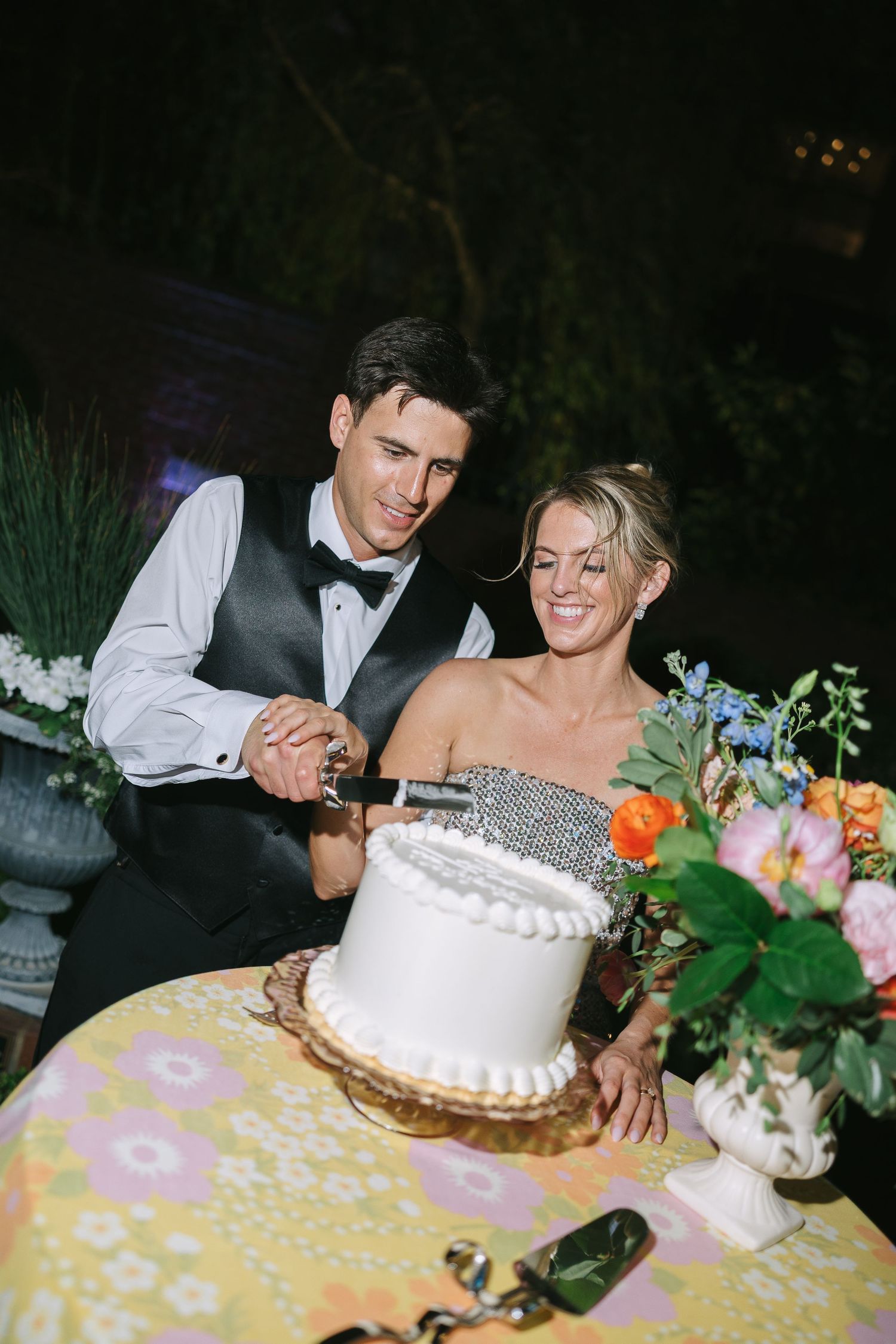 Couple sharing a joyful moment while cutting their wedding cake.