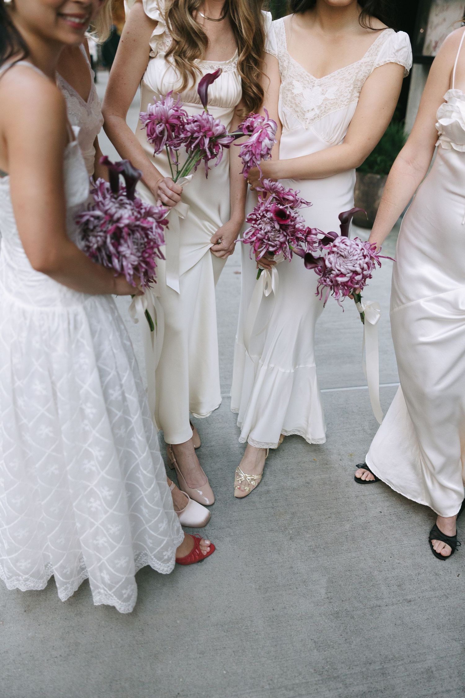 Wedding party members in white dresses gather showing their fashionable footwear choices.