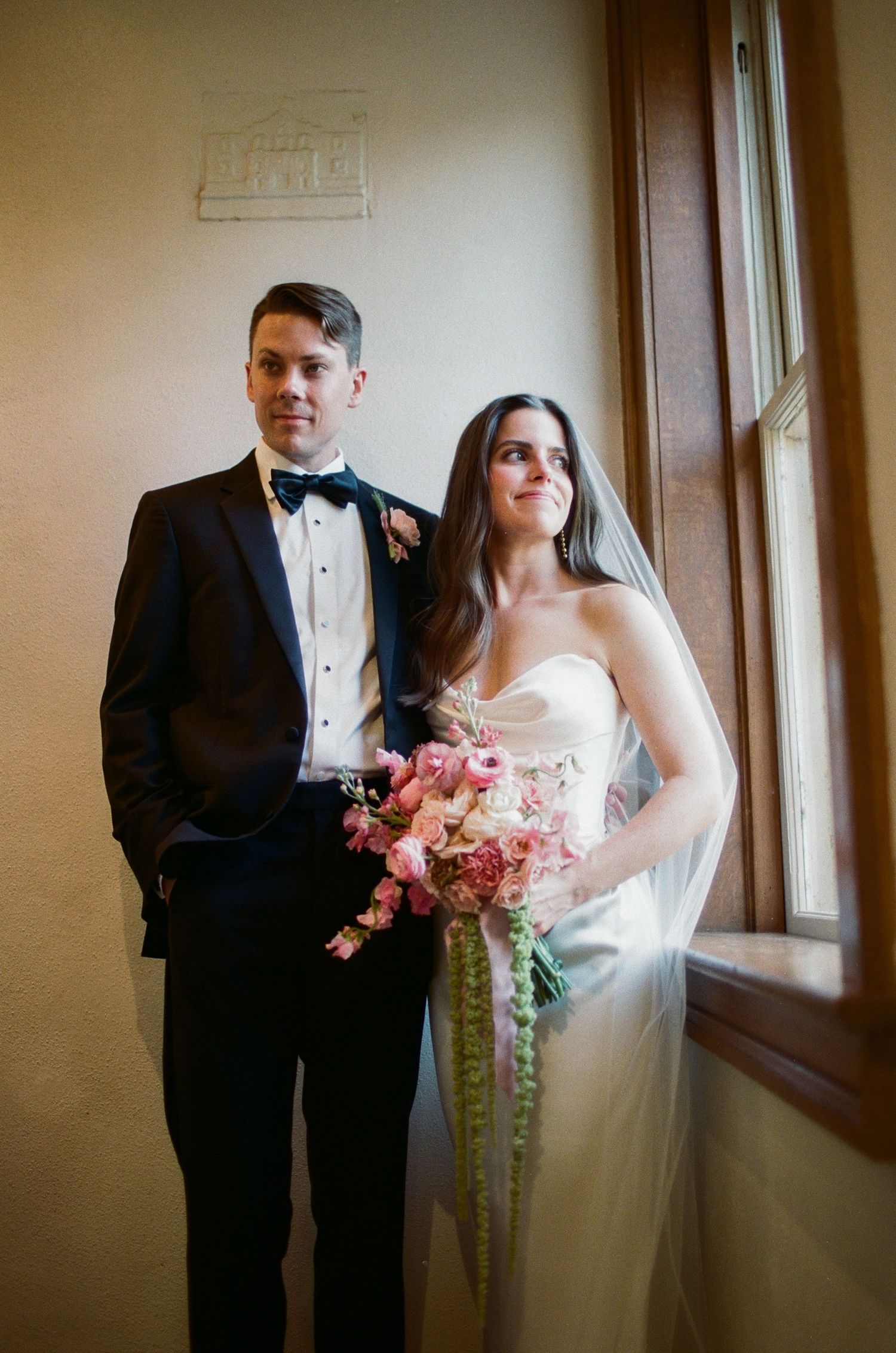 An intimate wedding portrait session near a window with natural light streaming in.