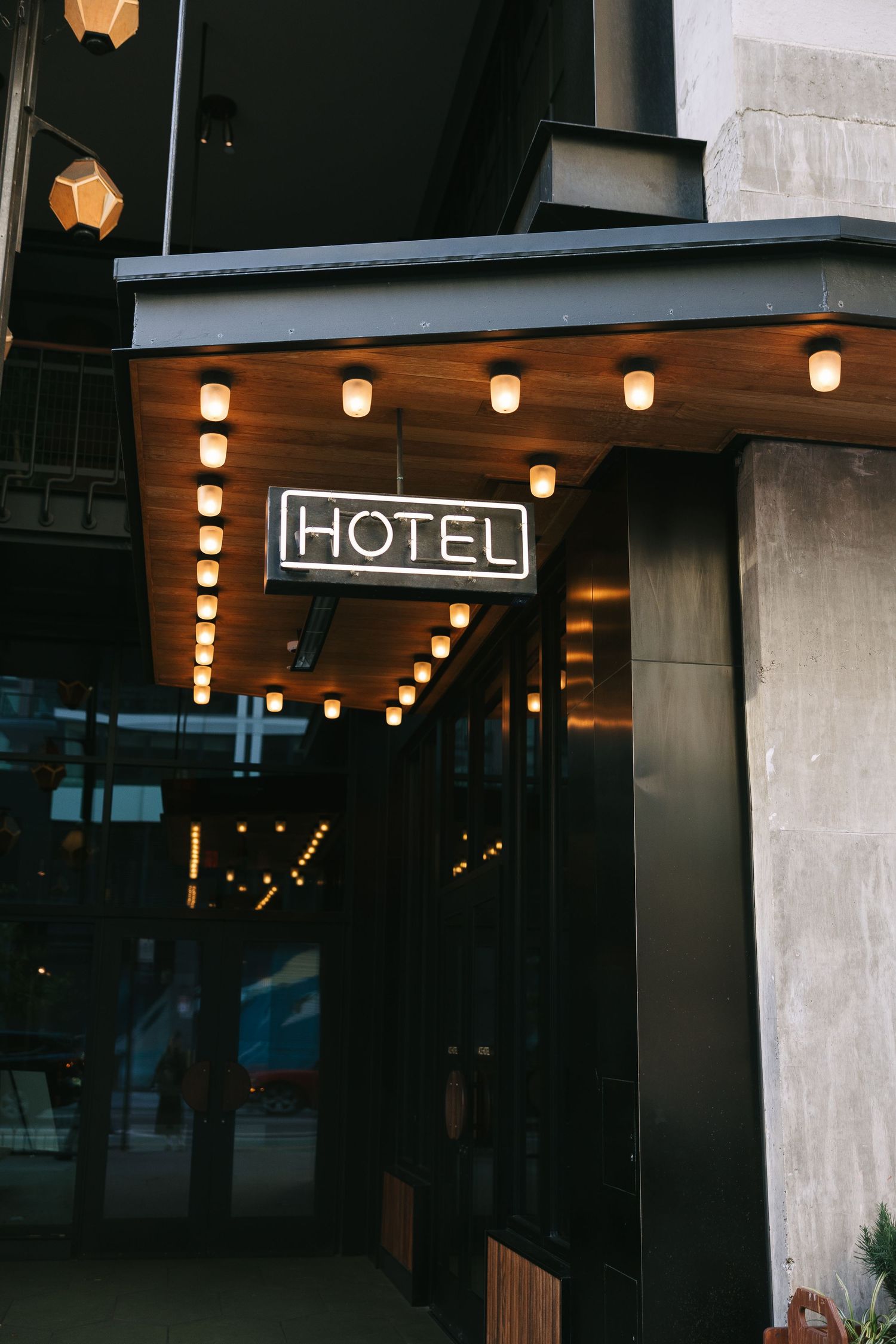Hotel entrance with illuminated lanterns and modern architectural details at dusk.