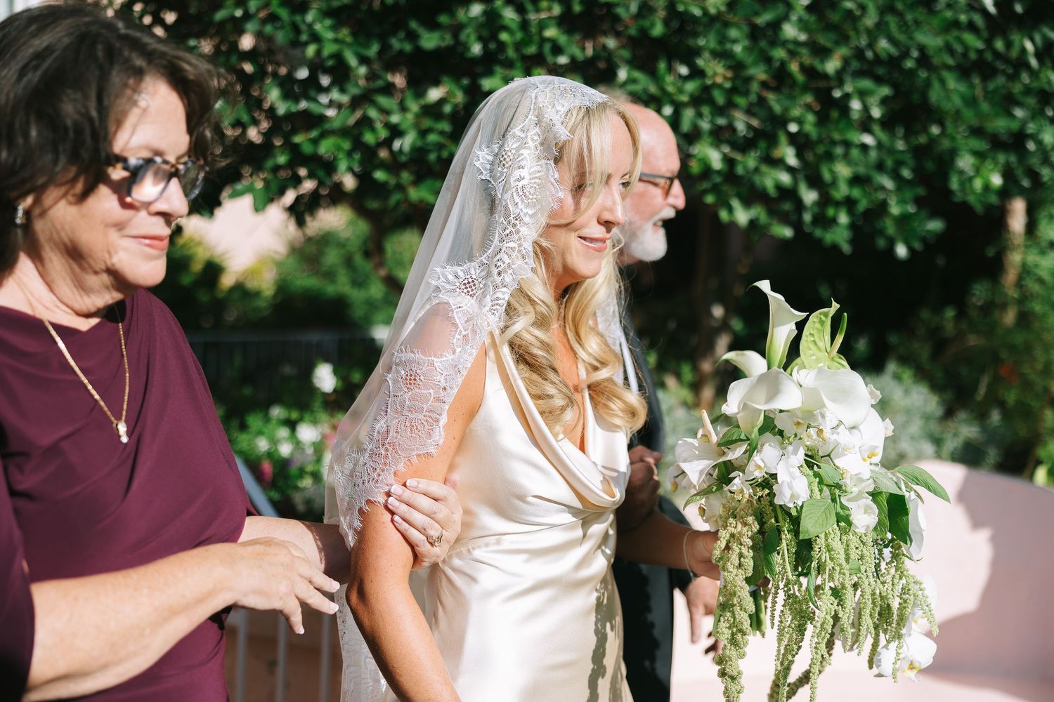 Wedding party members share emotional moments during outdoor celebration.