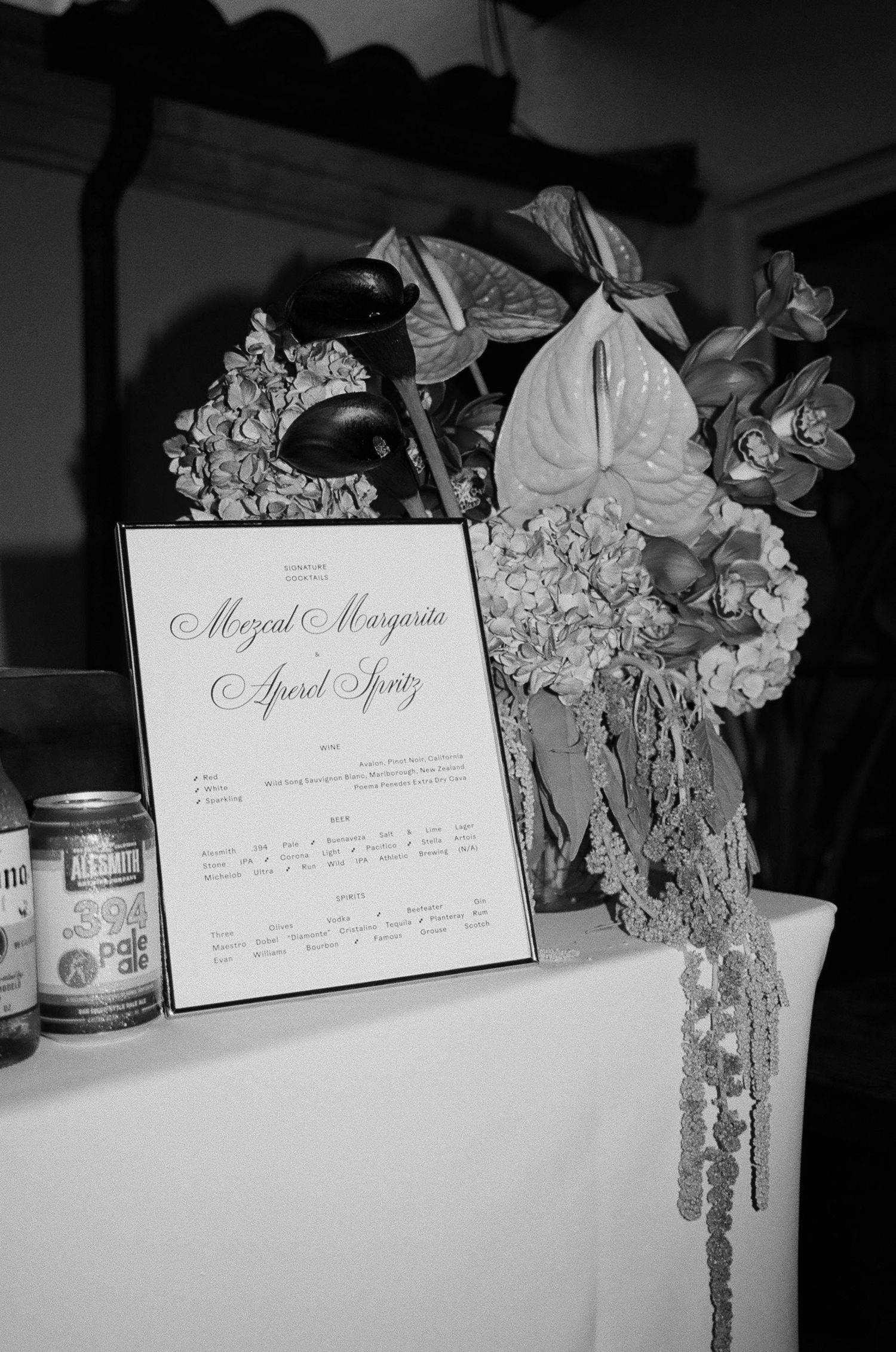 Black and white photo of a wedding menu display with floral decorations.