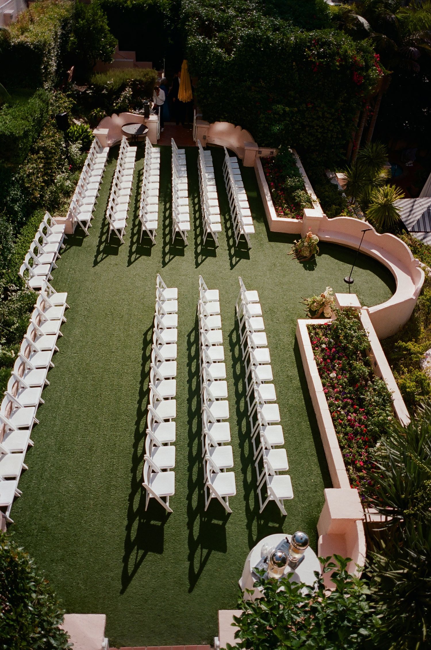 Rows of white chairs arranged on a green lawn for an outdoor wedding ceremony.