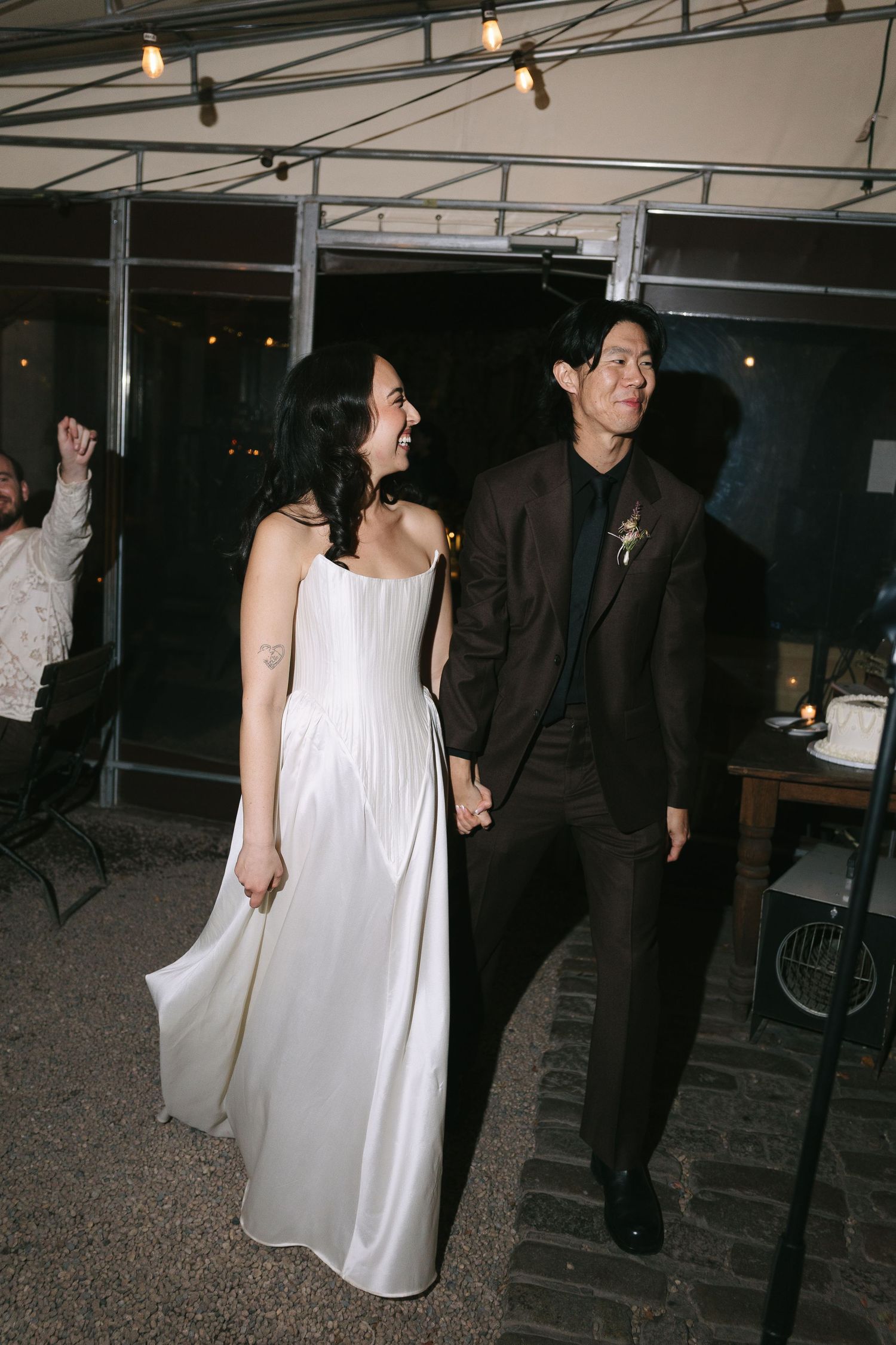 People in formal attire dancing and mingling at an indoor event space.