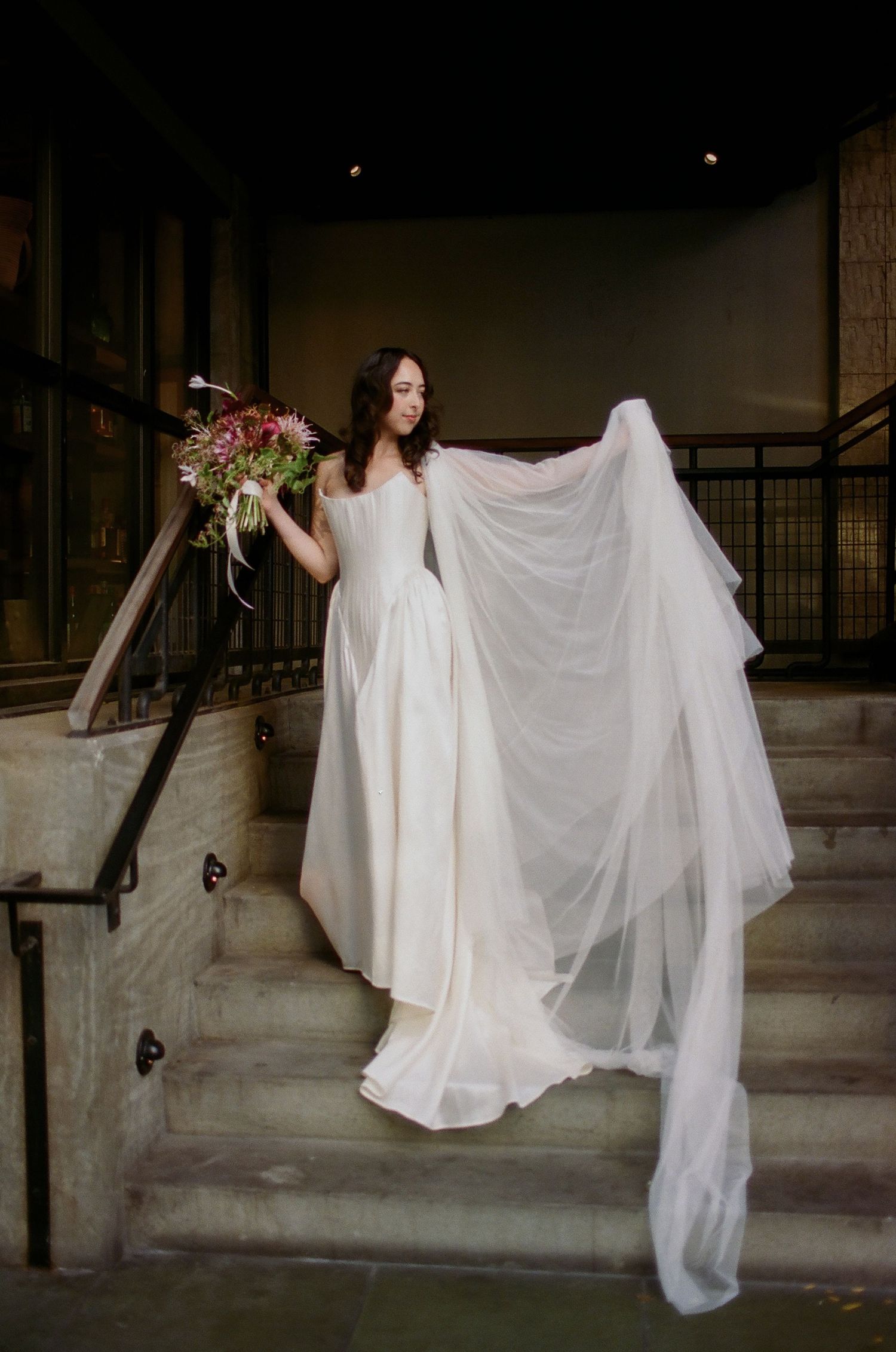 A series of photos showing a bride in a flowing white dress posing on stone steps with a delicate veil.