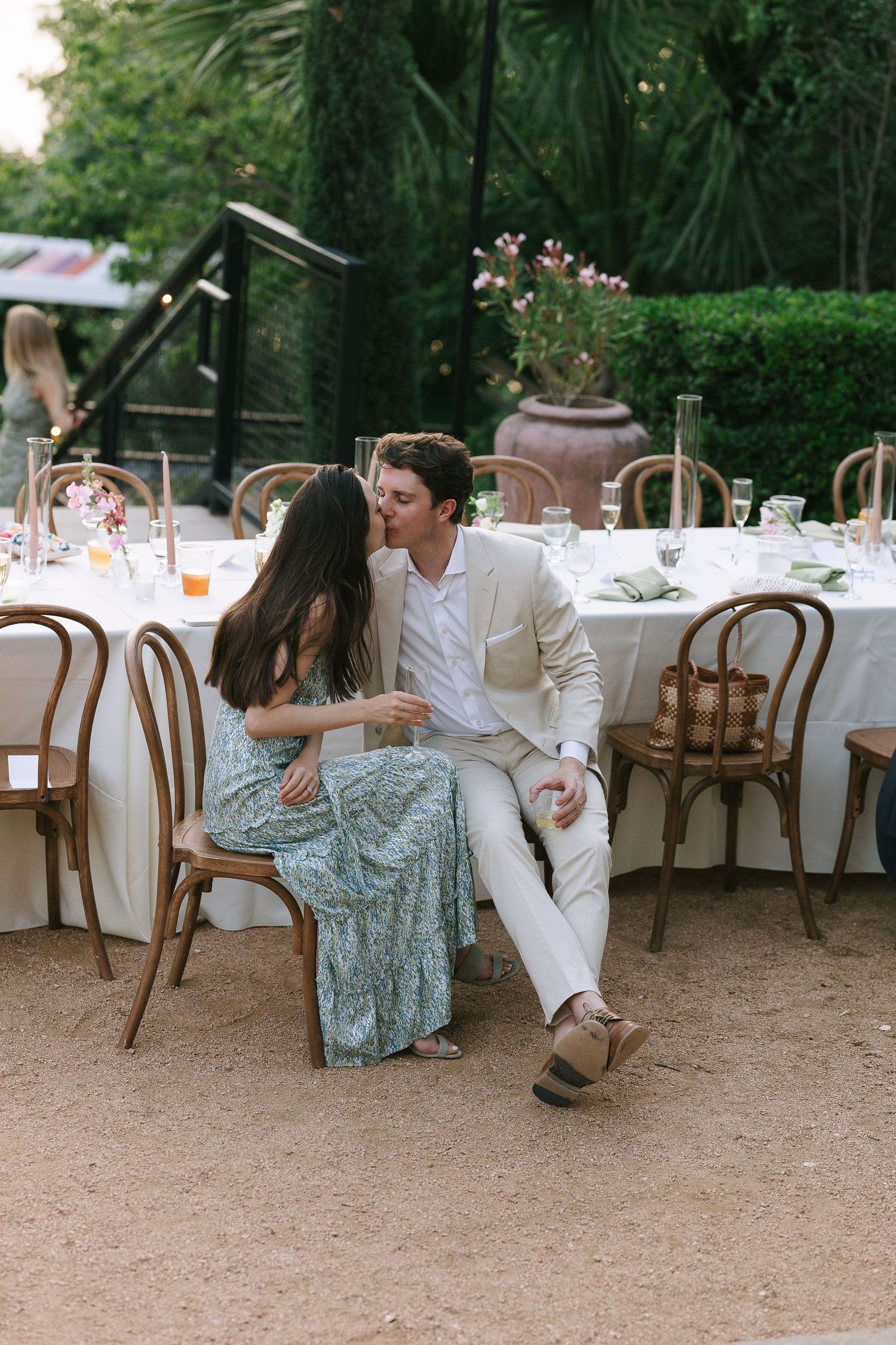 Elegant outdoor reception setup with bentwood chairs and white tablecloths.