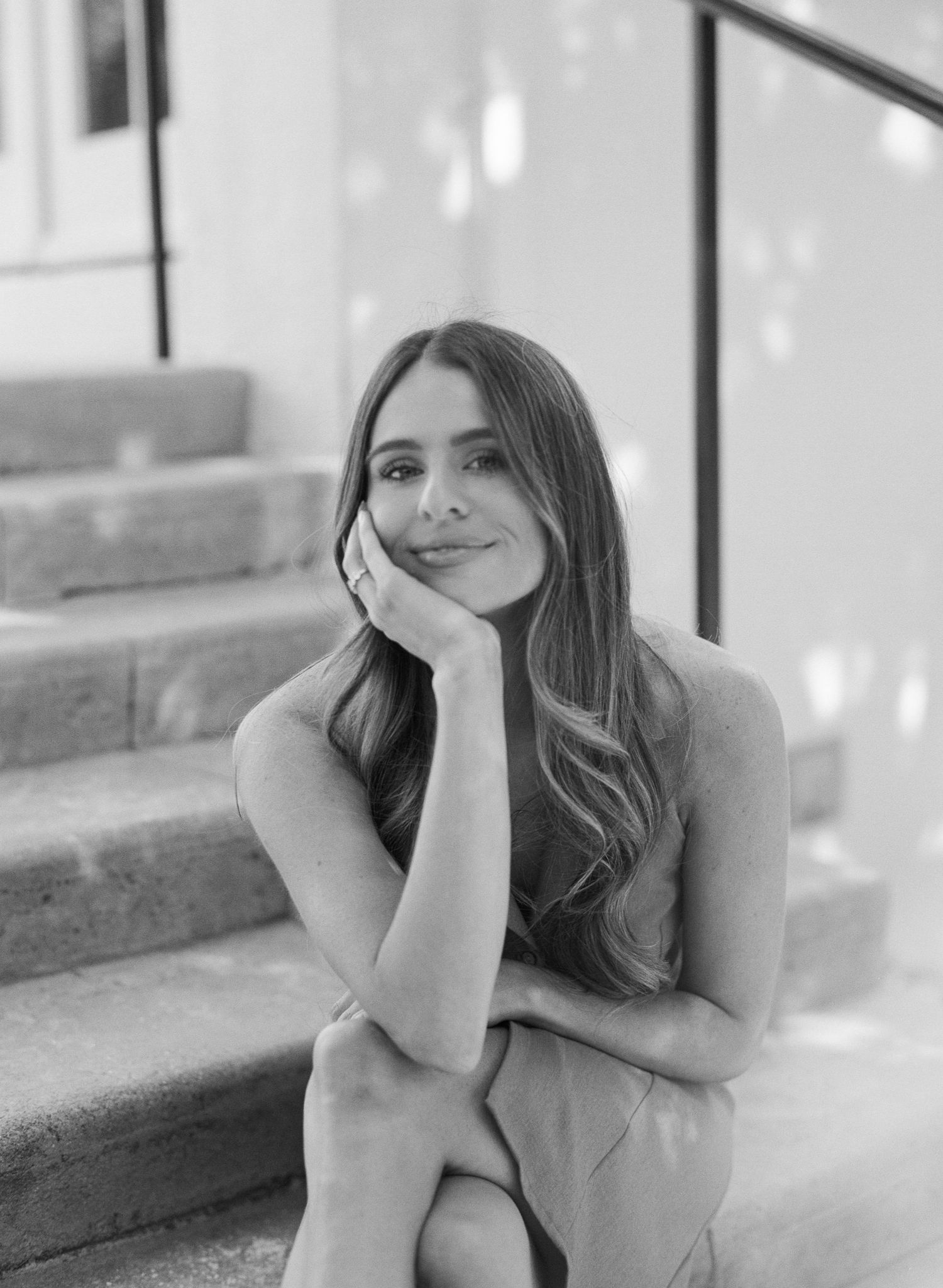 A black and white photo series shows a person in casual attire posing thoughtfully on concrete steps.