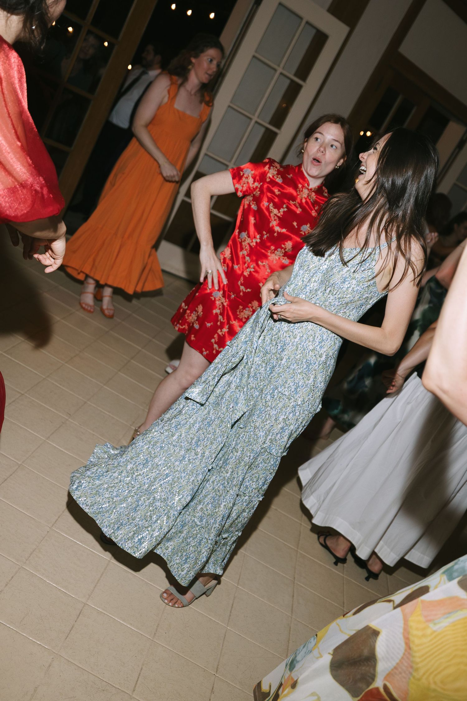 Wedding reception dance floor with guests in colorful dresses moving to the music.