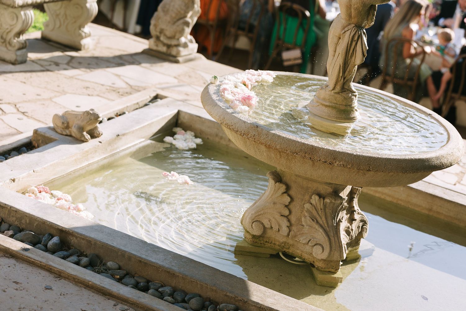 Ornate stone fountain detail at an outdoor wedding venue.
