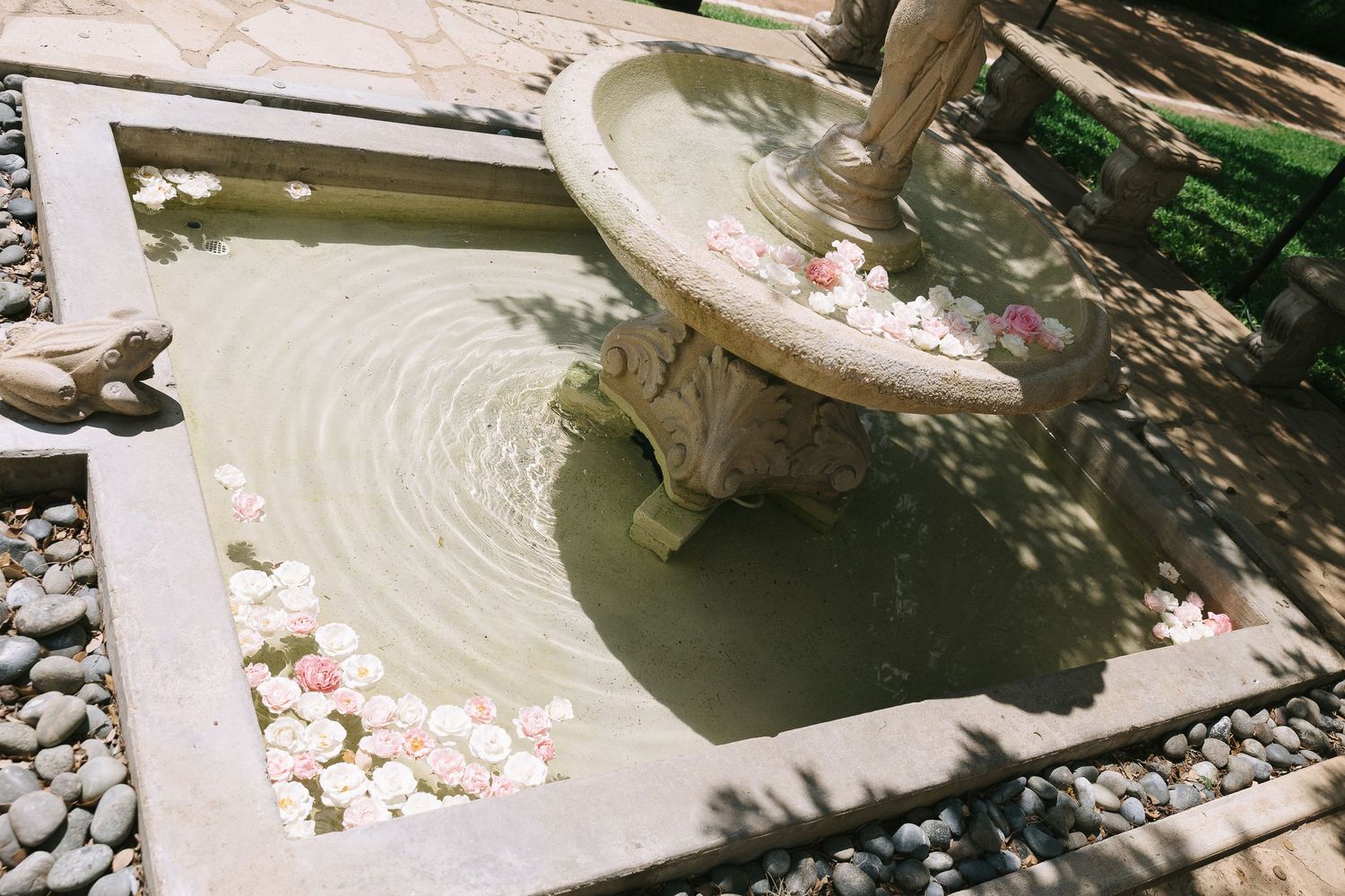 Artistic view of a decorative water feature with stone details and rippling reflections.