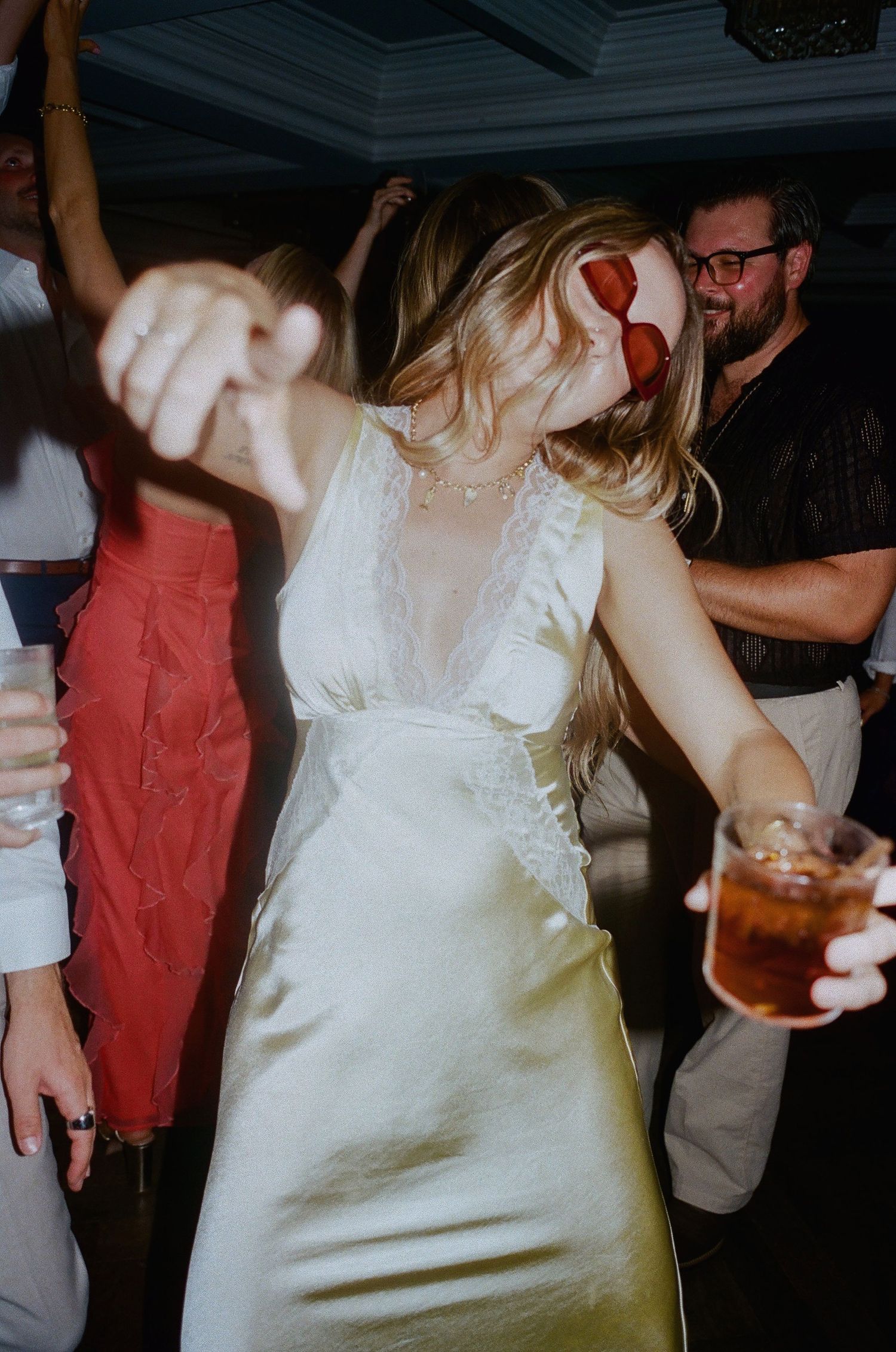 People dancing and celebrating at a wedding reception in formal attire.