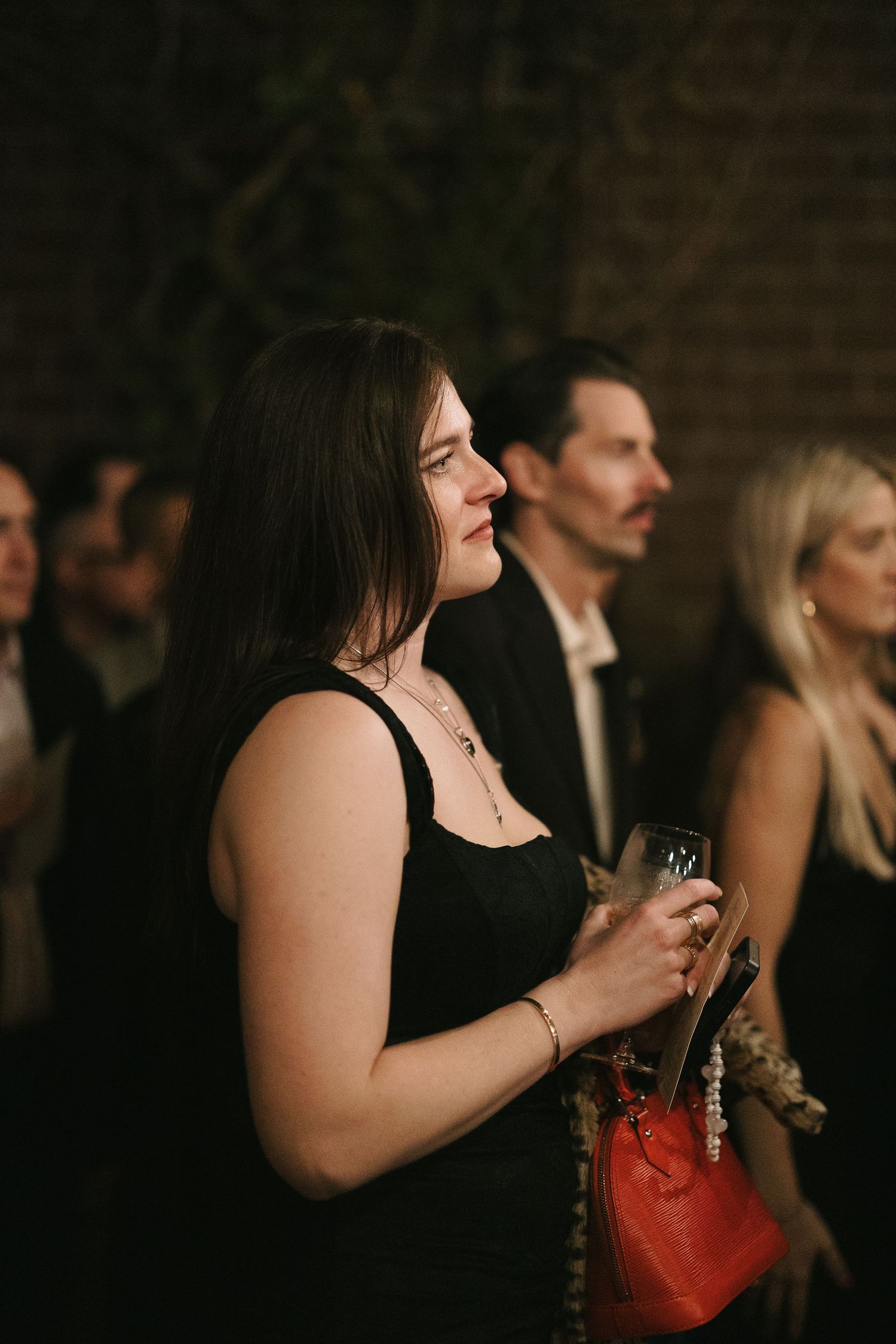 Wedding guests in formal attire watching the evening celebration.