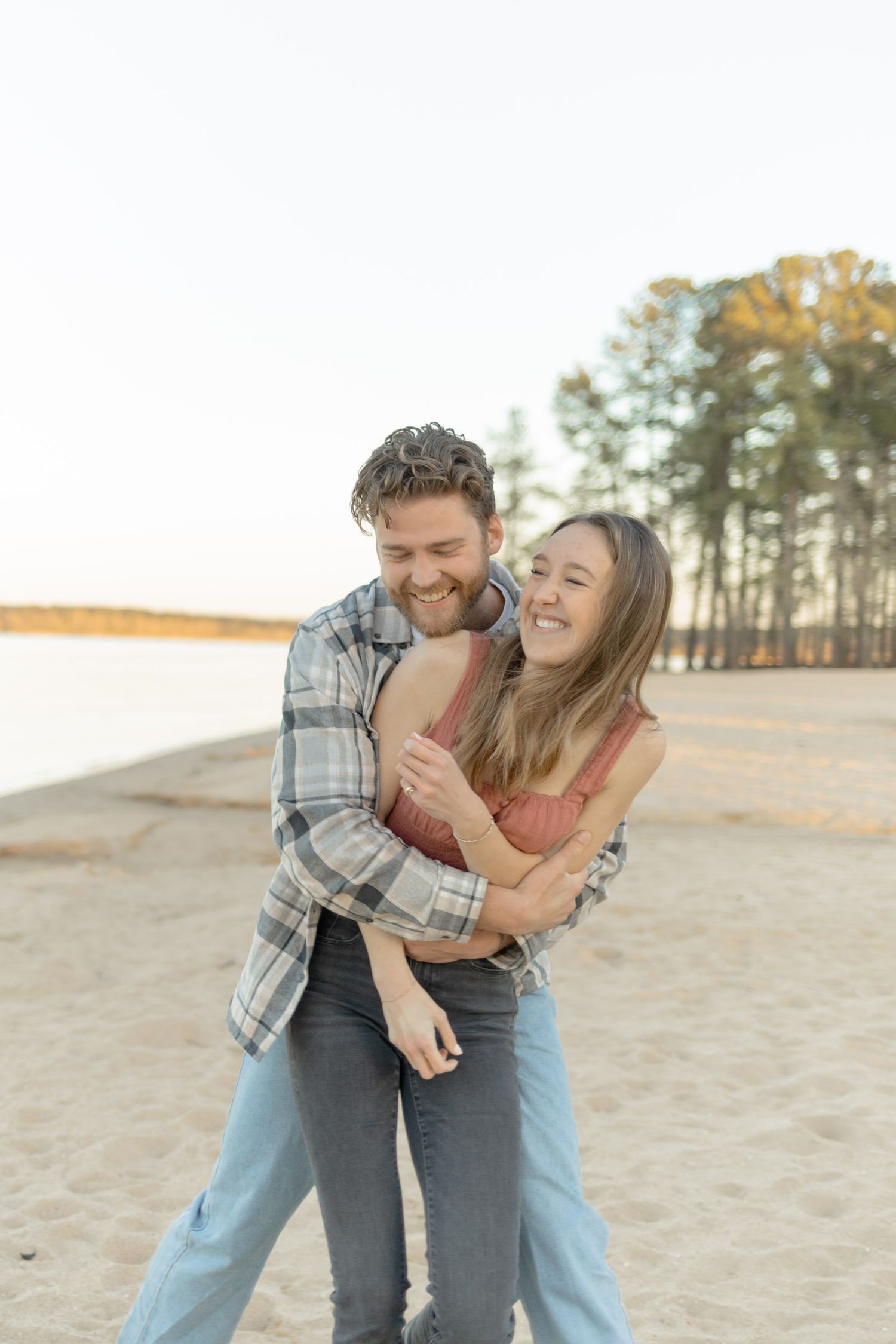 A romantic moment shared between a couple on a beach during sunset during their couples lifestyle photoshoot in Raleigh, North Carolina.