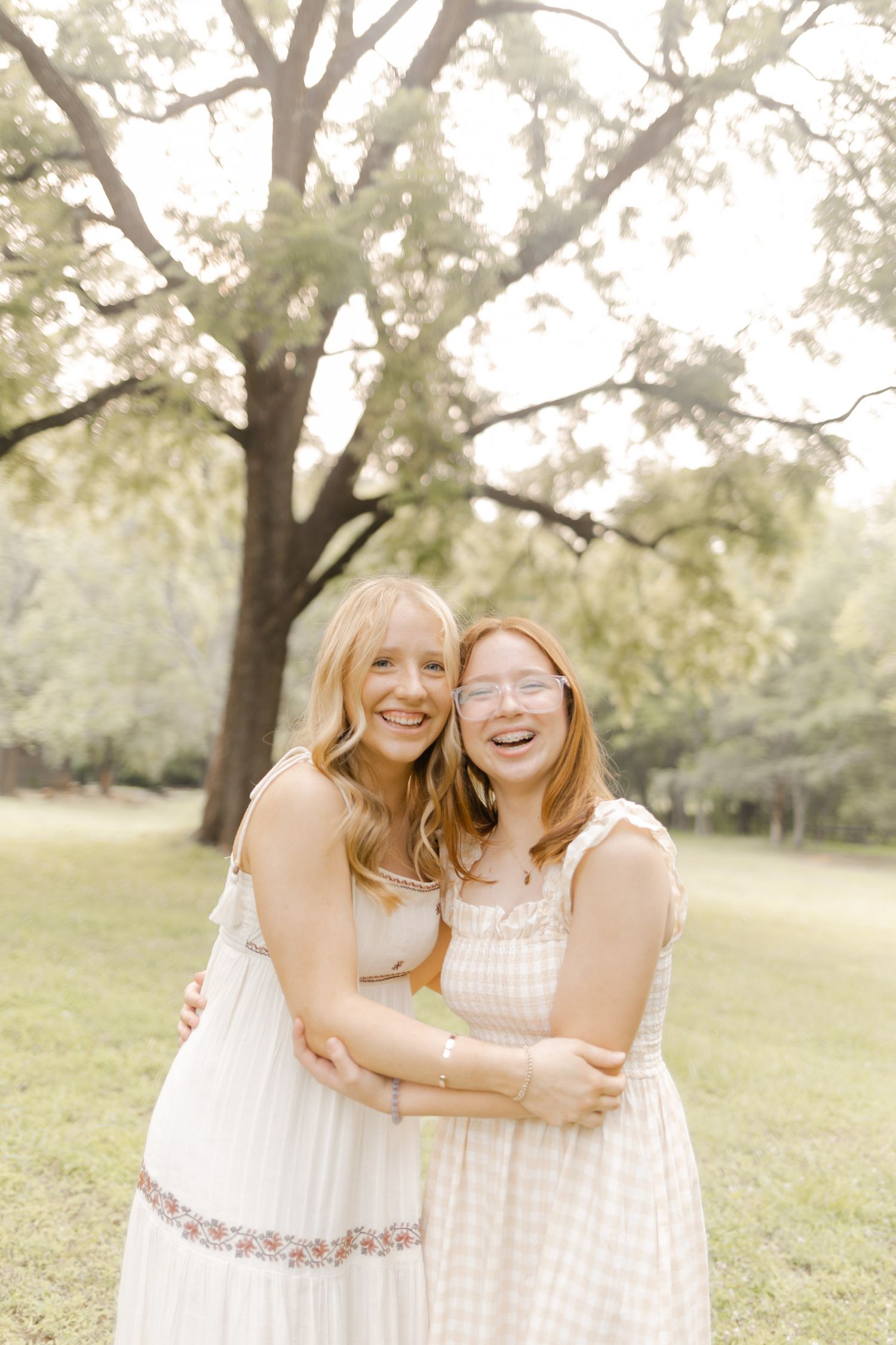 Two people share joyful laughter while embracing in a sunlit outdoor setting during photoshoot in Durham, NC.