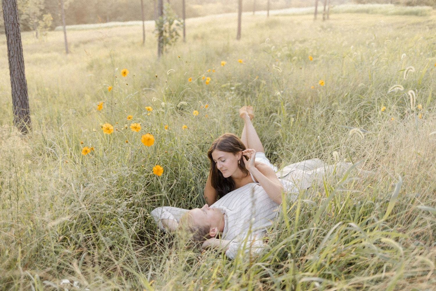 A couple relaxing together in a meadow with scattered wildflowers at photoshoot in Chapel Hill