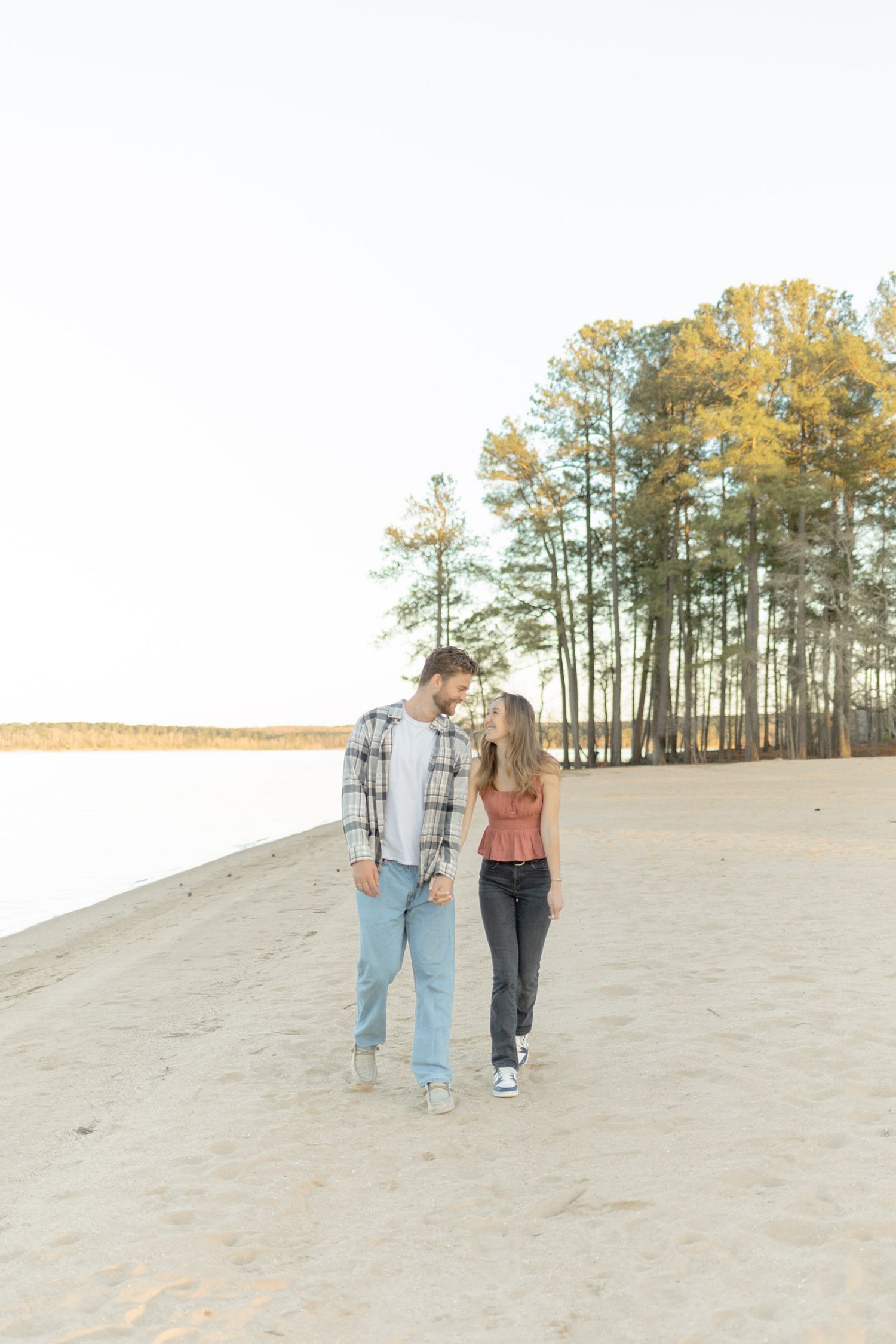 Romantic couple sharing intimate moment while walking on sandy hill during golden hour in Raleigh, North Carolina.