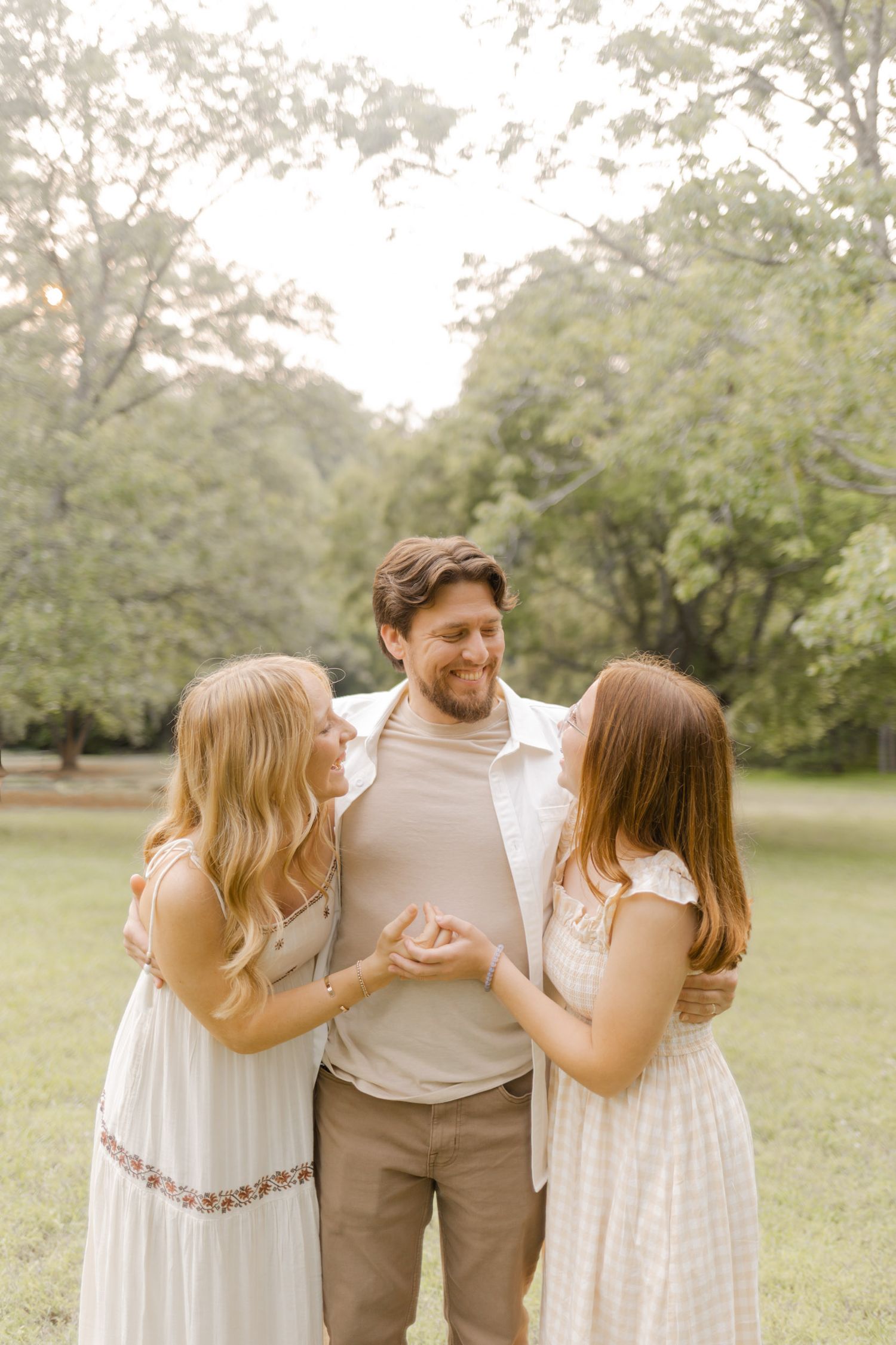 A group laughs together while posing for casual outdoor photos in a park setting in Durham, North Carolina photoshoot.