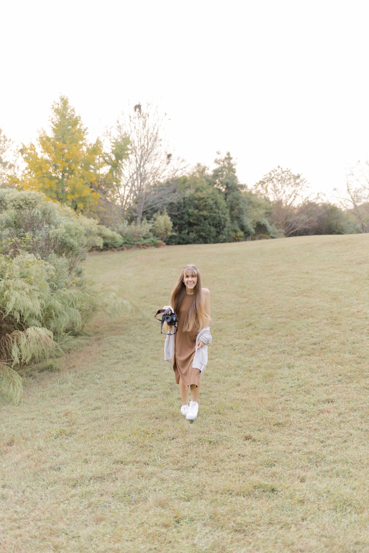 A grassy hillside path during autumn with trees and foliage in the background at photoshoot in Chapel Hill