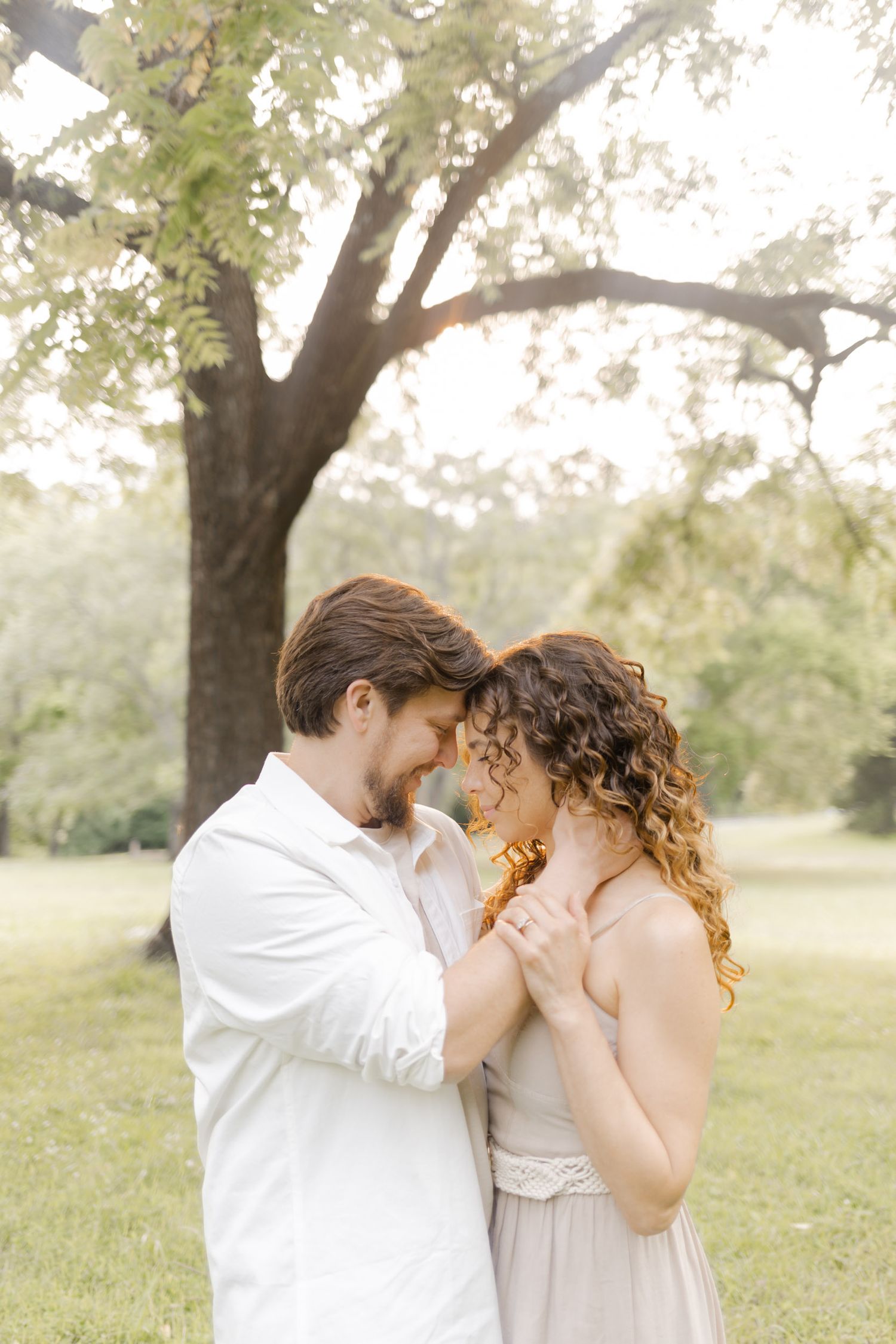 An intimate moment captured between two people in soft, natural lighting outdoors making a light, airy, creamy photo.