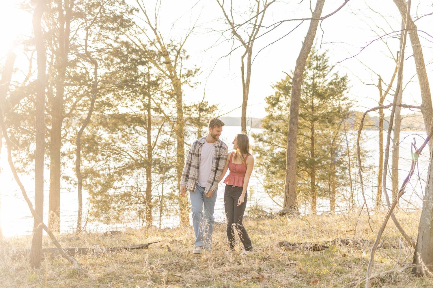 Silhouettes of a couple walking through a forest landscape during golden hour in Raleigh, North Carolina.