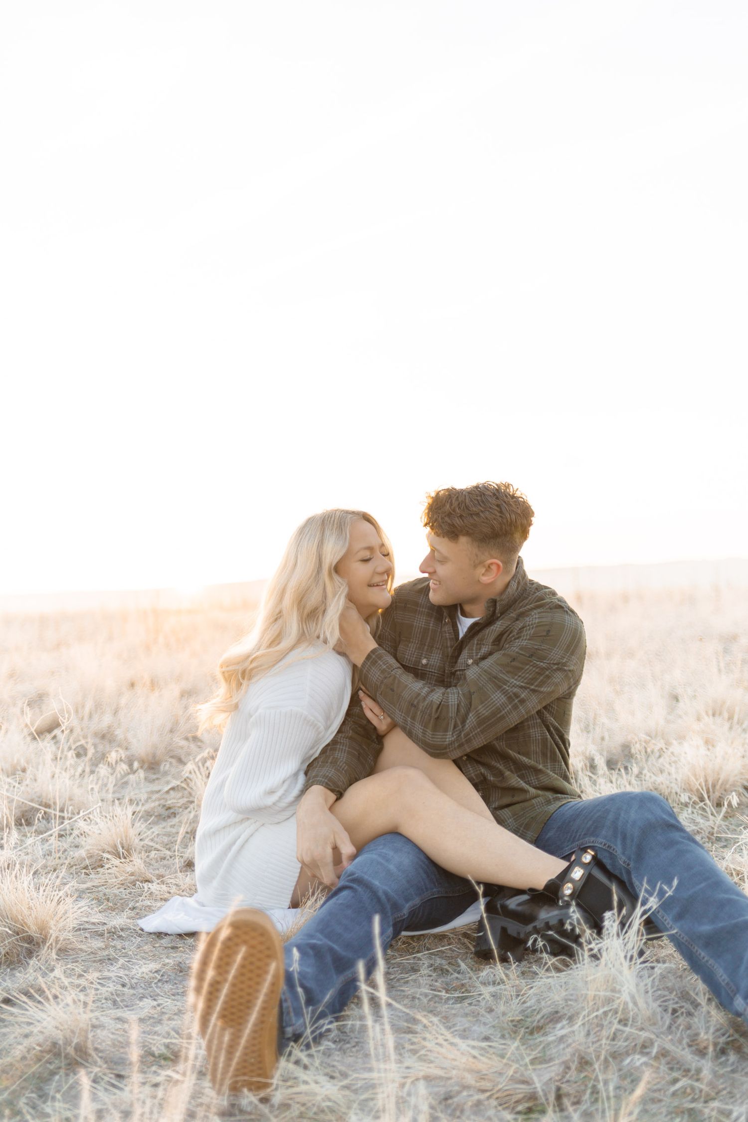 Intimate couple poses together in a golden field during sunset photoshoot at Antelope Island, Utah