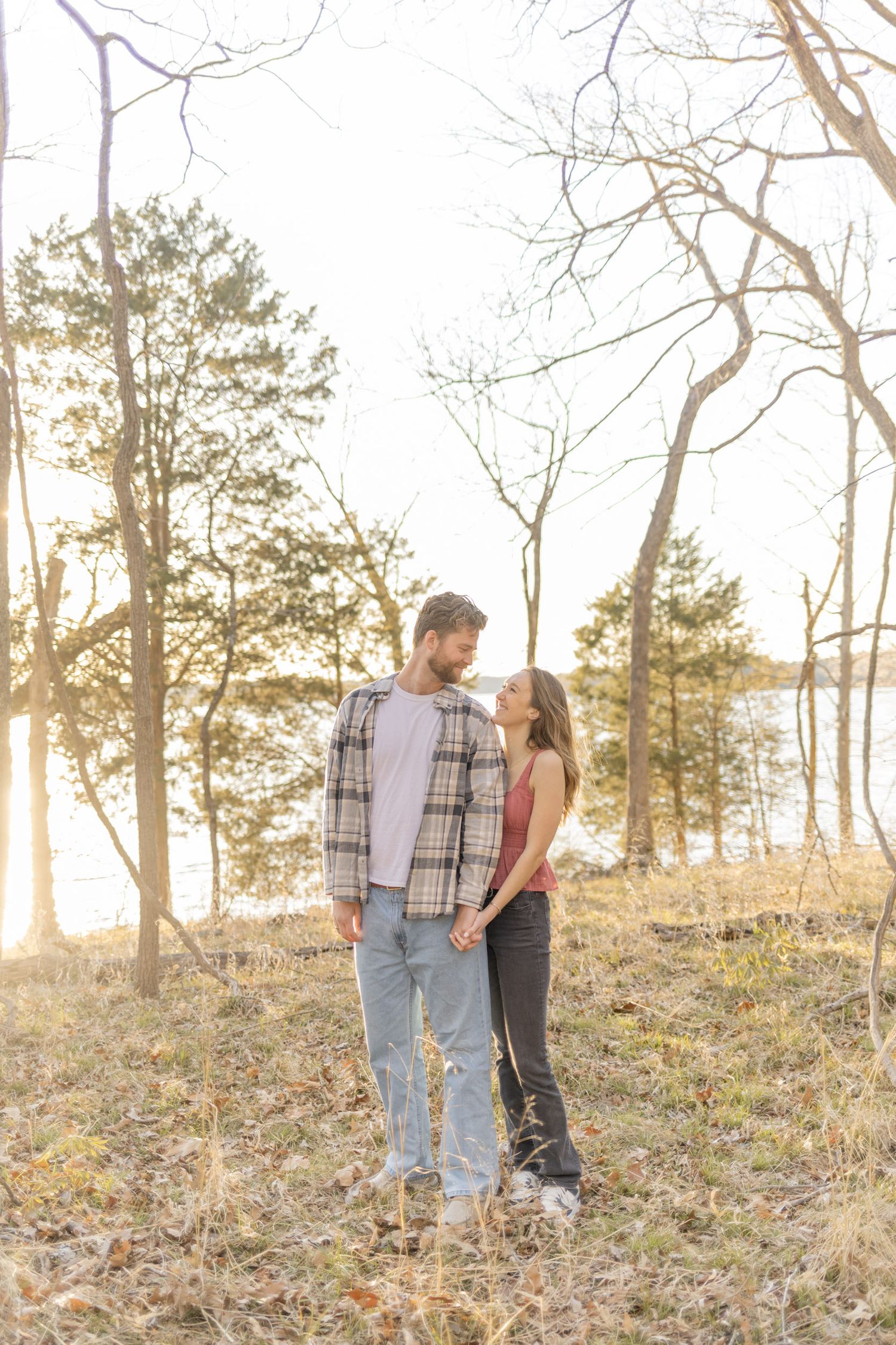 Two people share tender moments while walking through a scenic wooded area at sunset in Raleigh, North Carolina.