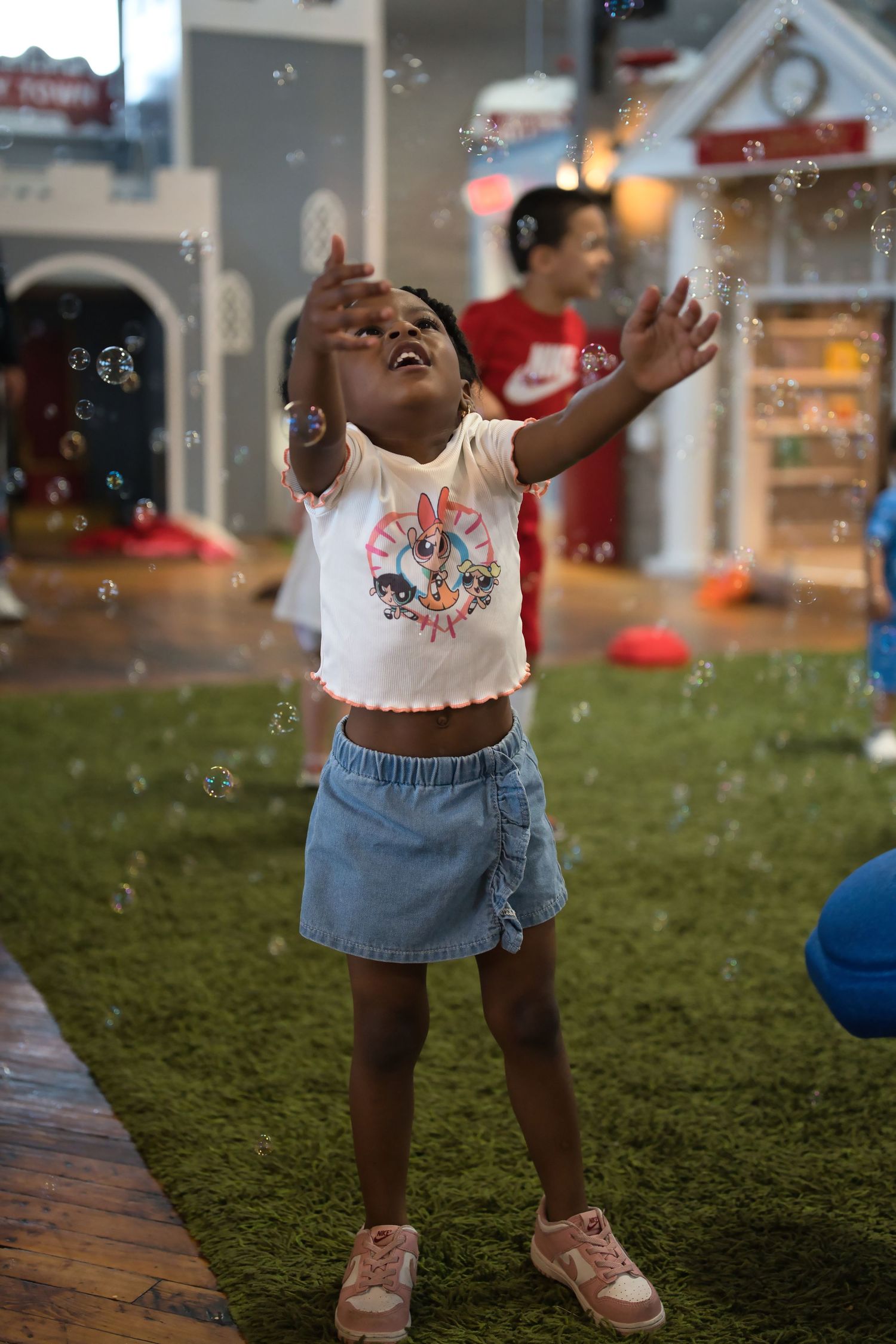 Small child playing with bubbles while wearing casual summer outfit outdoors.