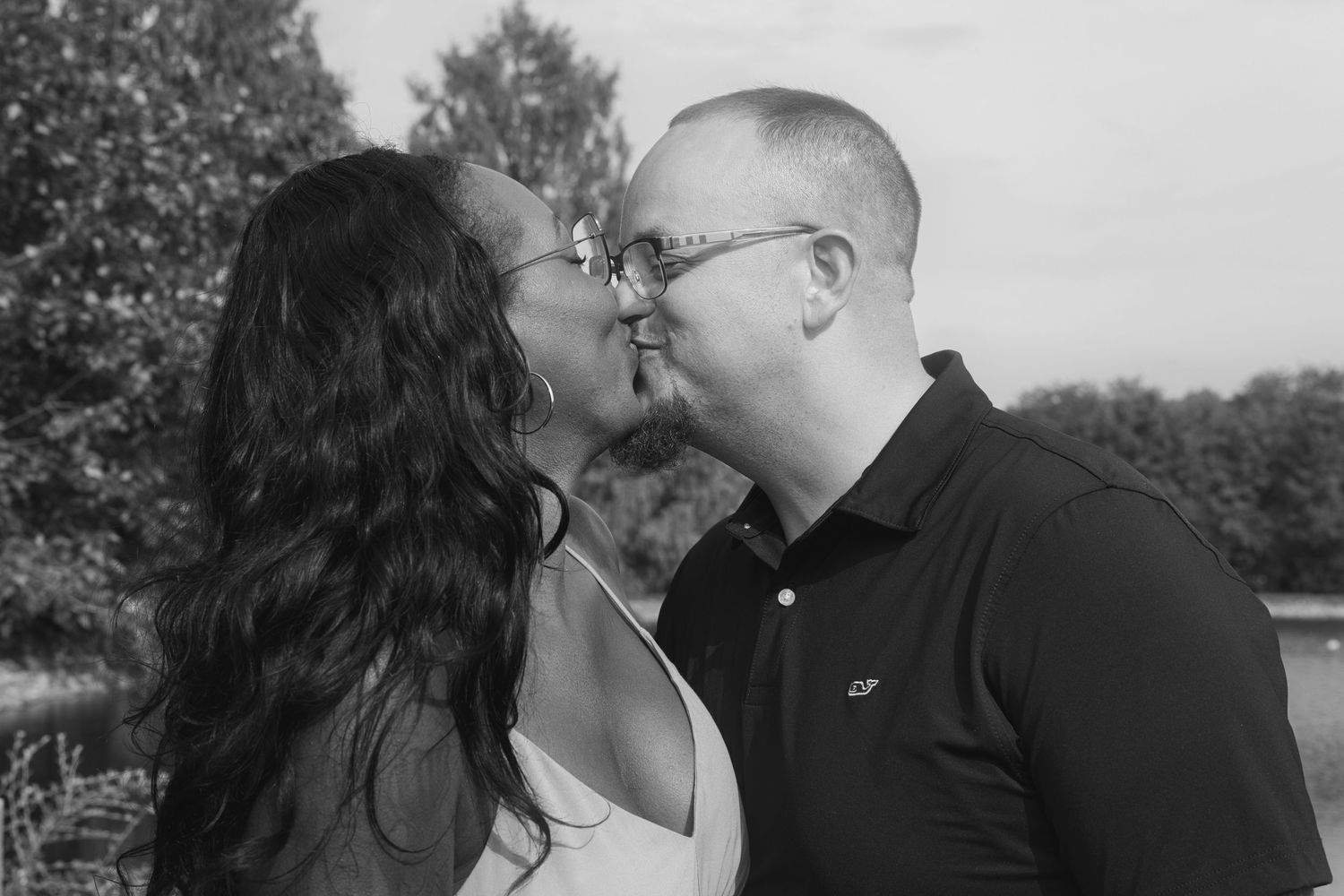 A series of black and white photos showing a romantic couple sharing tender moments outdoors.
