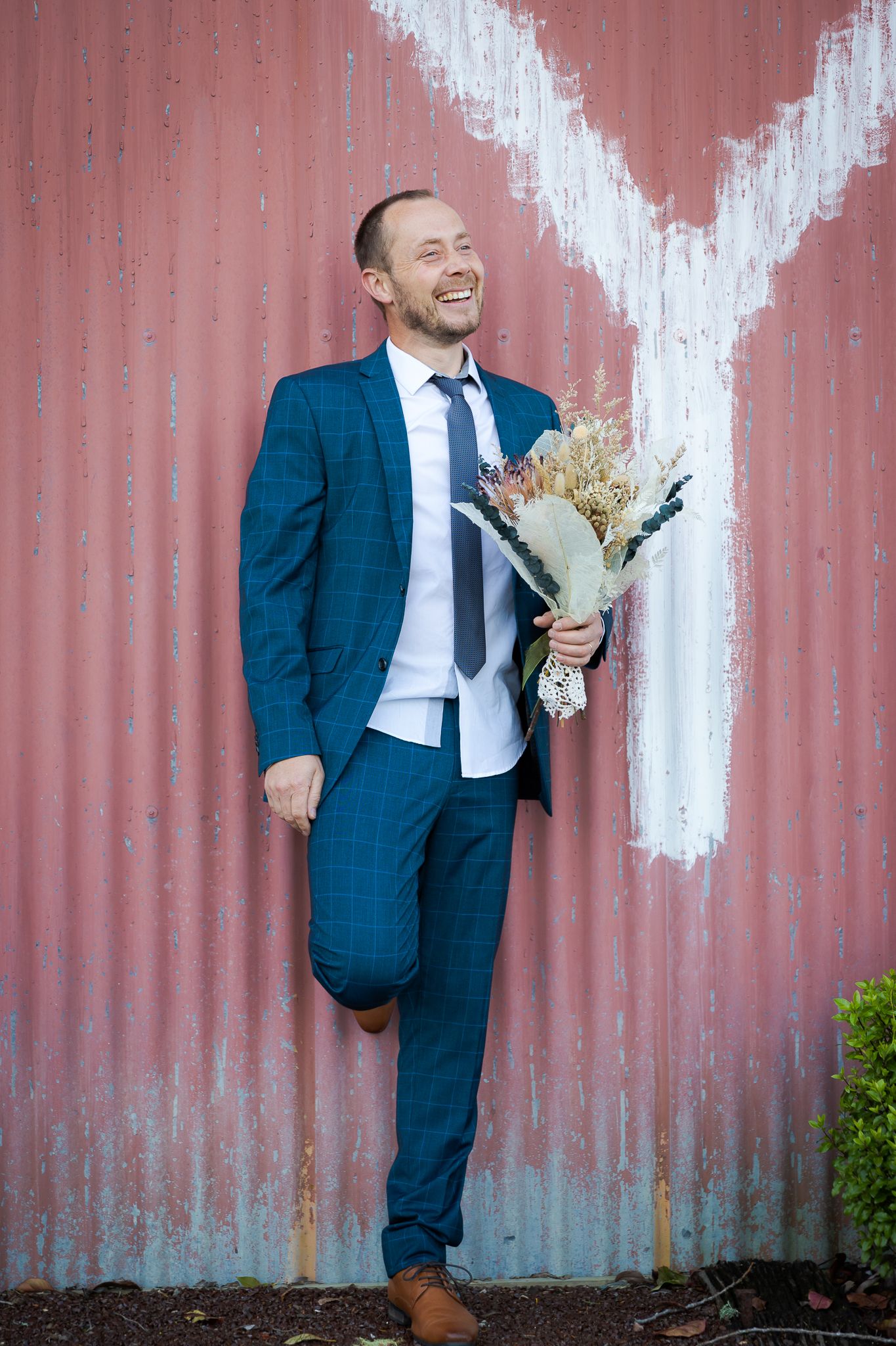 Auckland North Shore Wedding: Groom portrait holding flowers at the barn wedding venue.