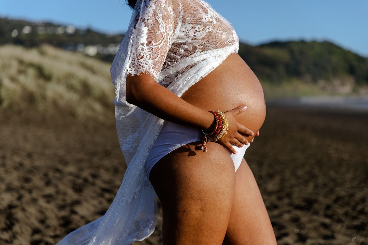 Muriwai Beach Maternity Photography: Elegant side profile of a pregnant woman during an Auckland session.