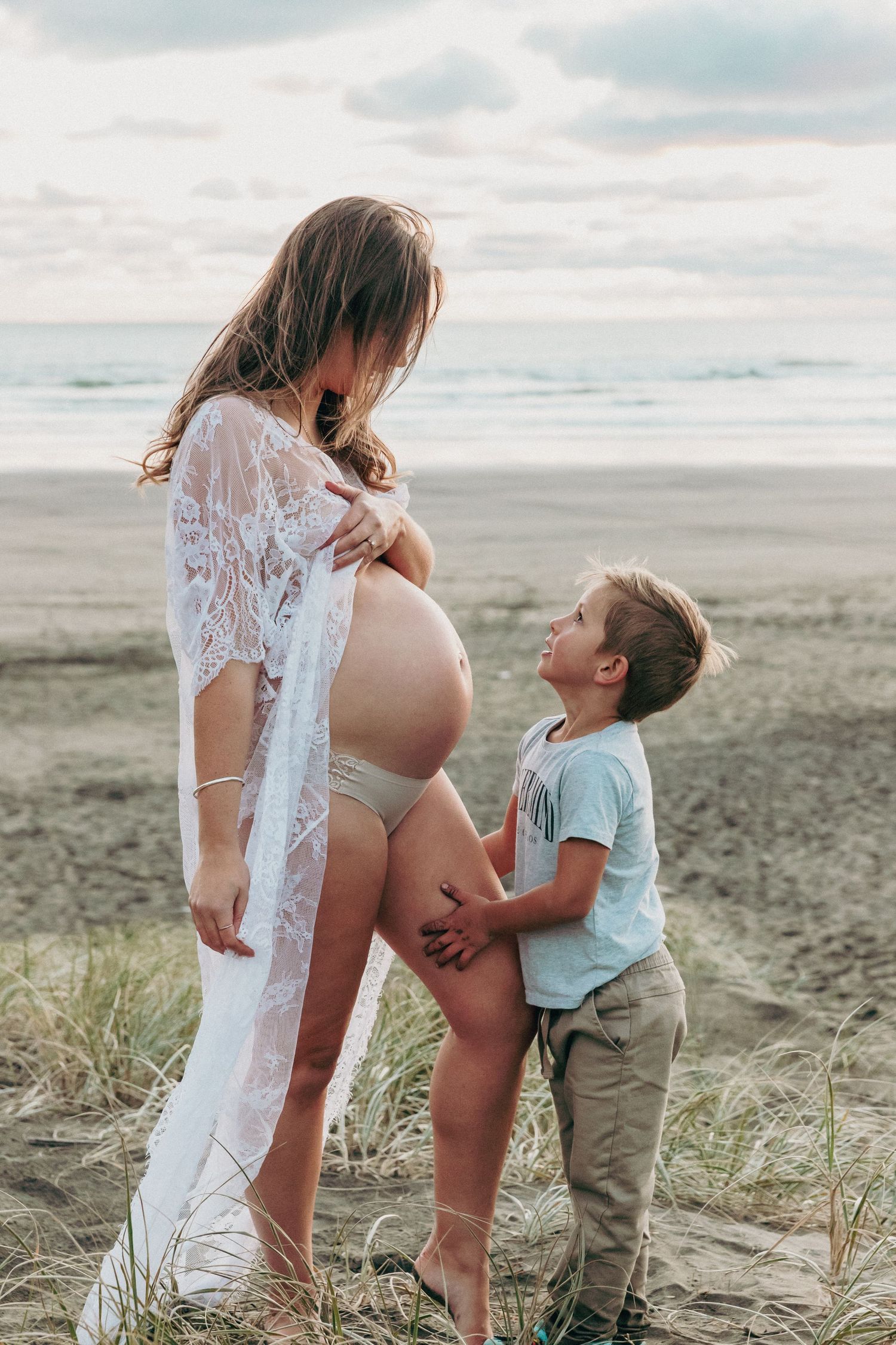 Auckland Maternity and Family: Son looking up at mother's pregnant belly bump, captured in North Shore.