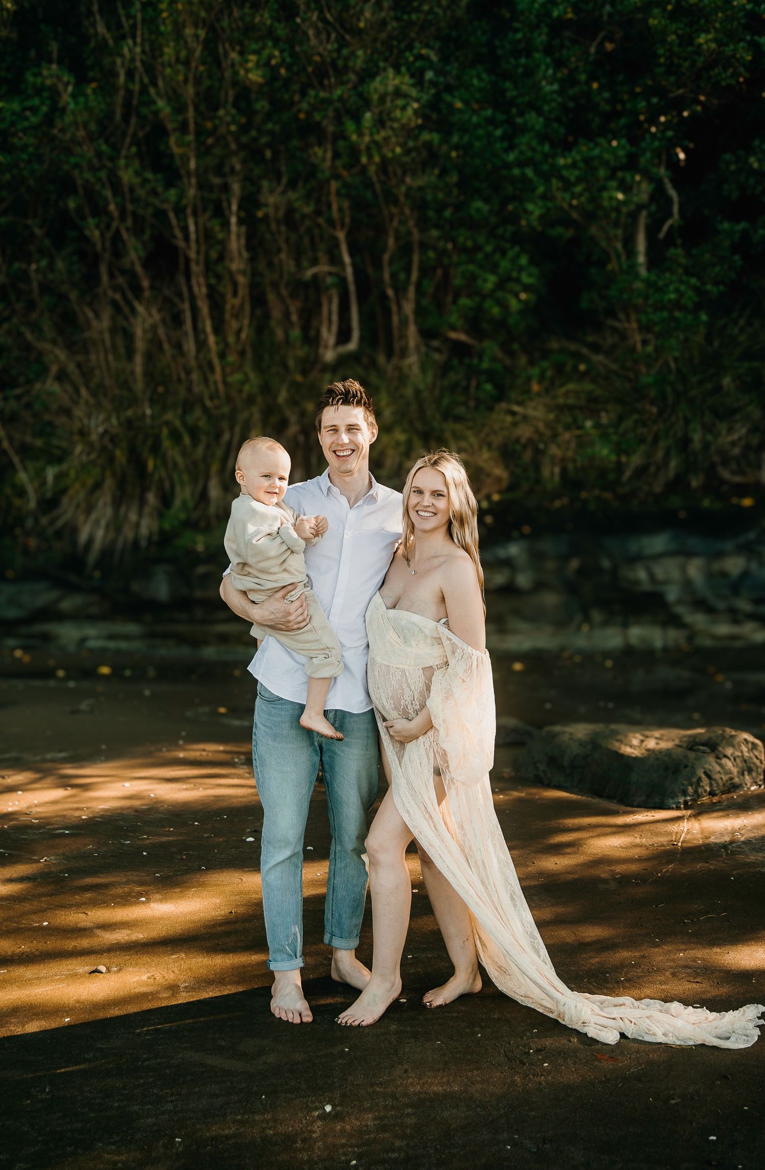 Long Bay Beach Maternity Photoshoot: Pregnant woman in long flowing blush lace dress, Auckland photographer.