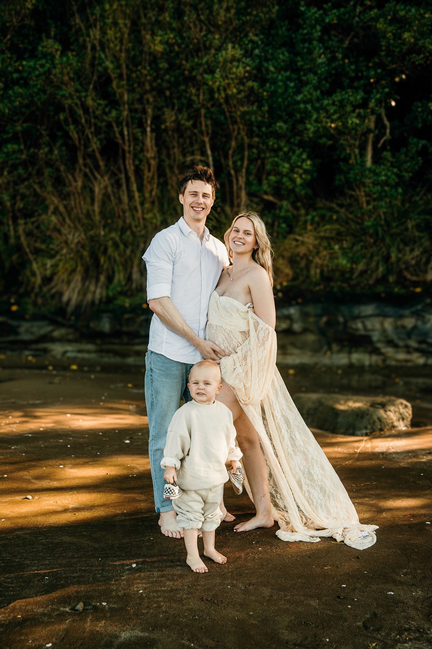 Long Bay Beach Maternity Photography: Couple embracing during sunset. Top Auckland North Shore photographer.