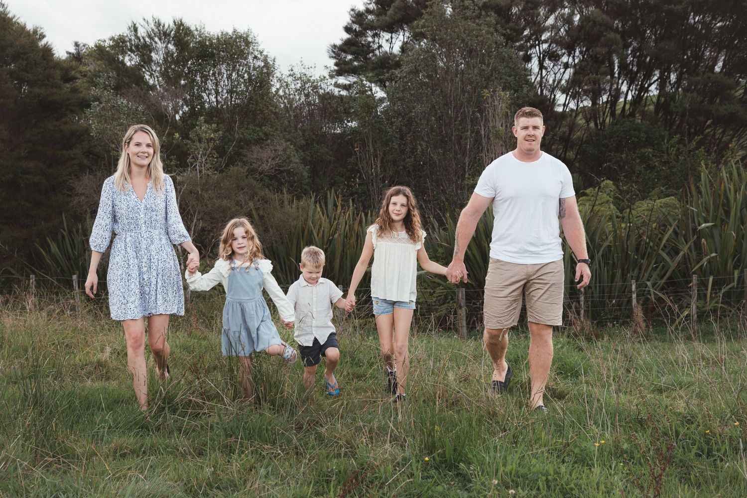Auckland North Shore Family Session: Family dressed in blue playing together in a beautiful grassy field