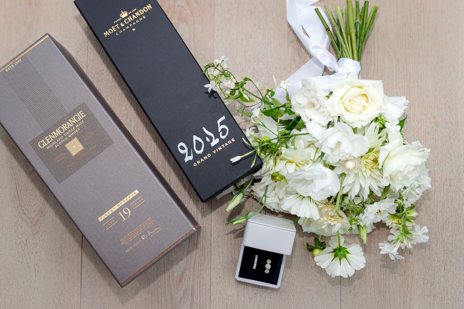 Auckland North Shore Wedding Details: Wedding rings and bouquet displayed during the bridal preparation session.